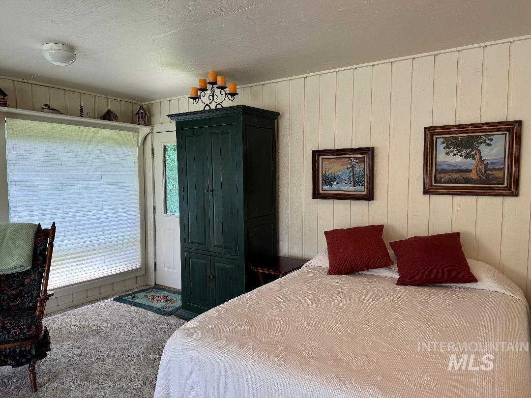 Carpeted bedroom with wooden walls