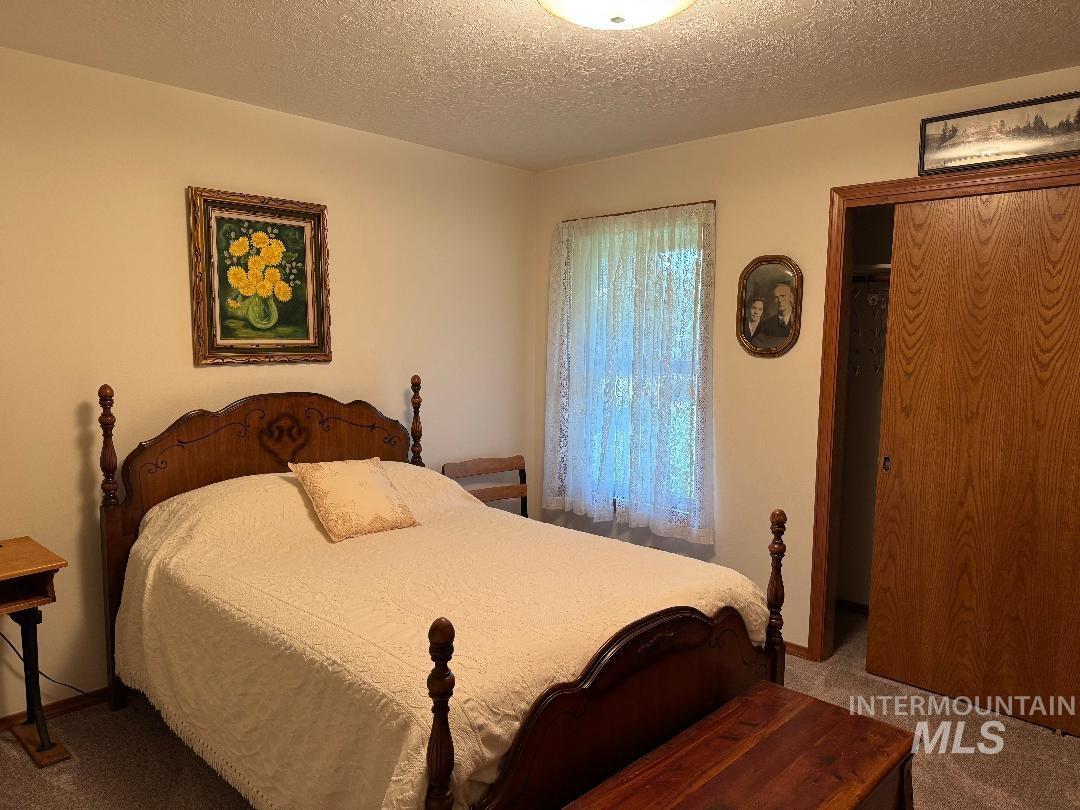 Bedroom featuring carpet flooring and a textured ceiling
