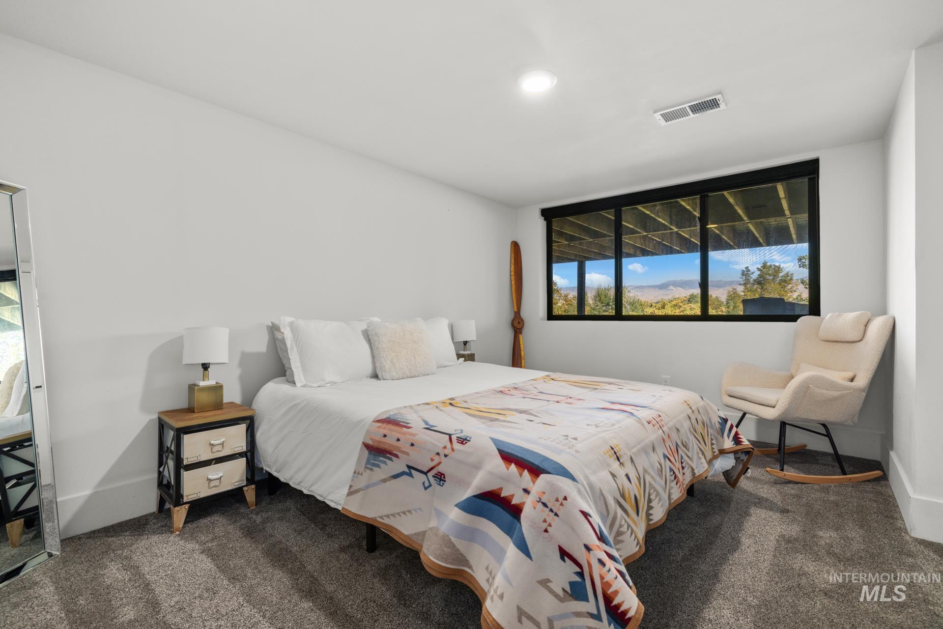 Bedroom featuring dark carpet and baseboards