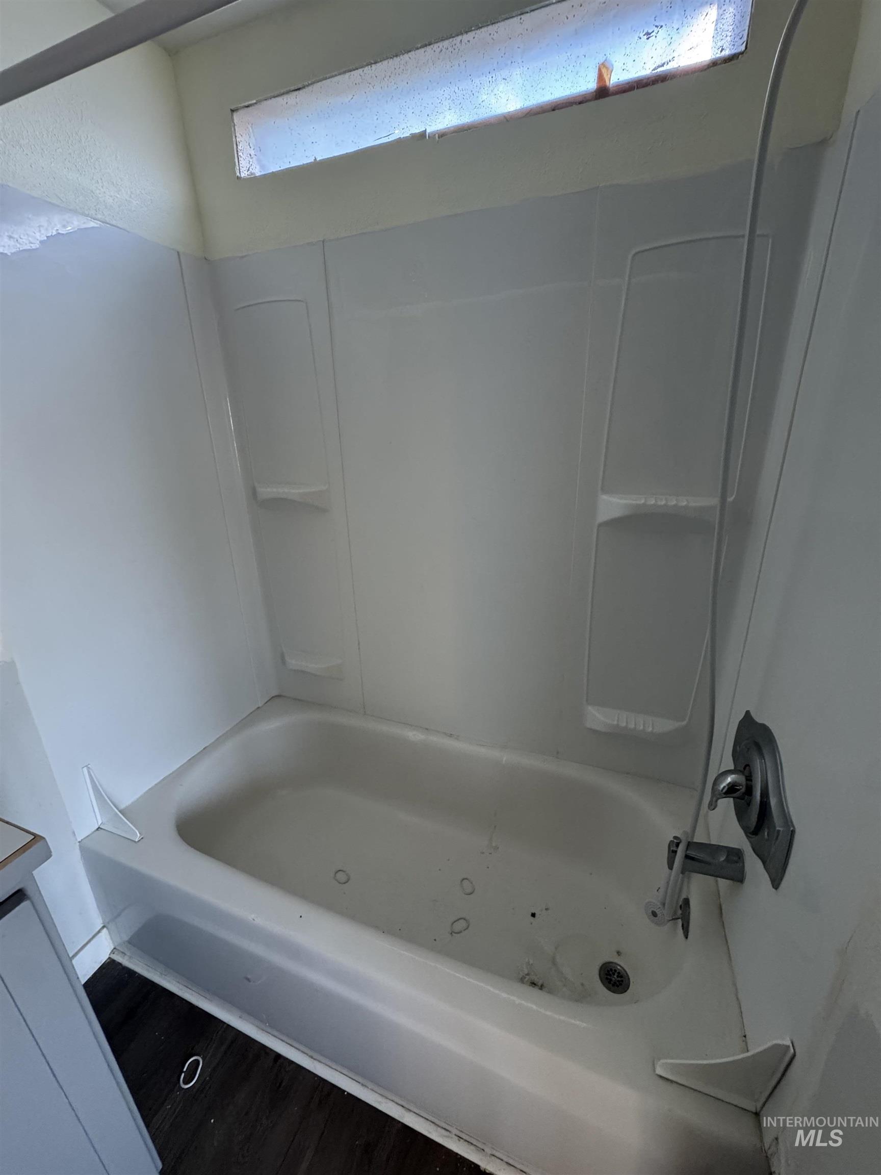 Bathroom featuring  shower combination and dark wood finished floors