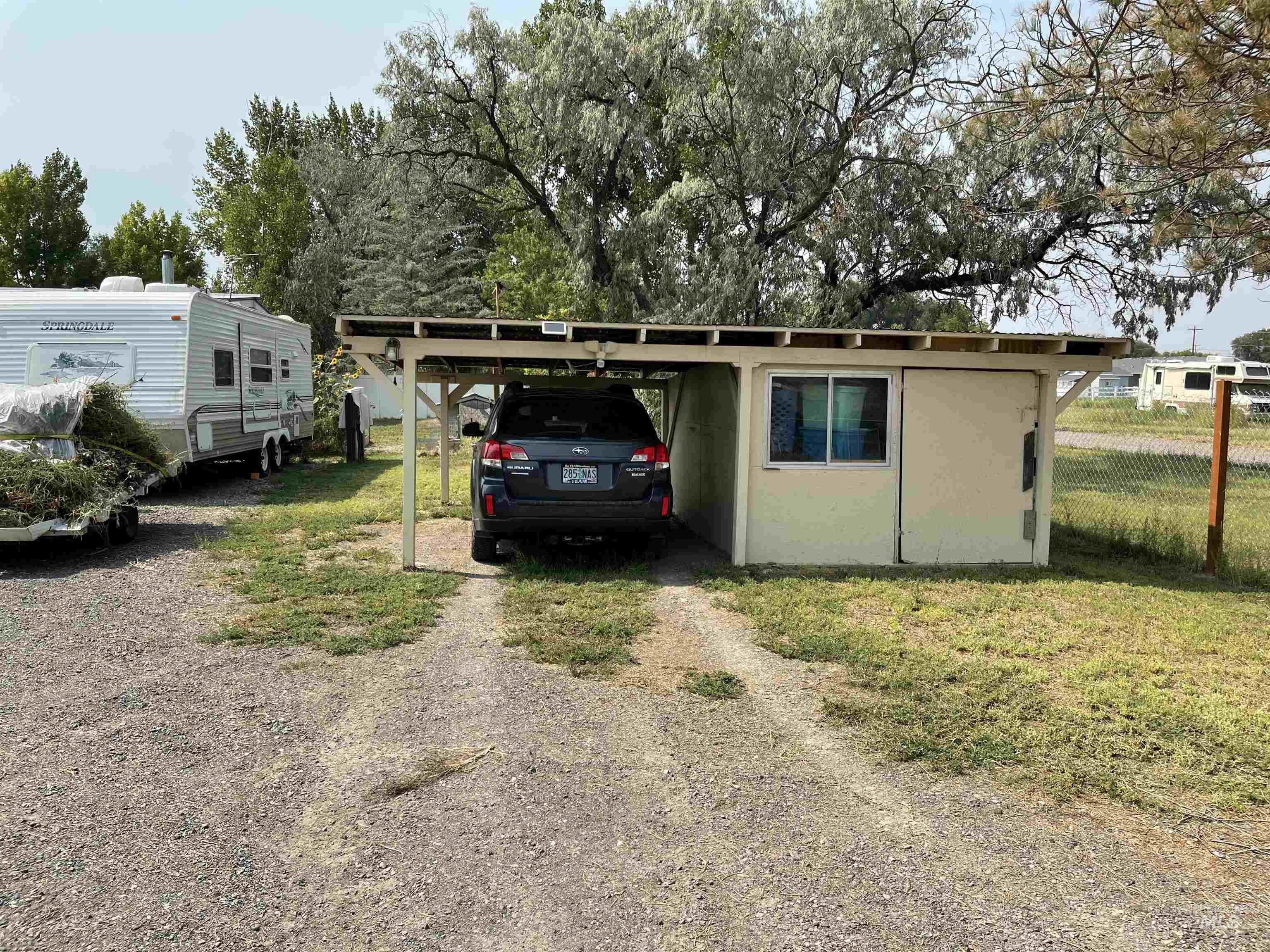 View of outdoor structure with a carport and driveway