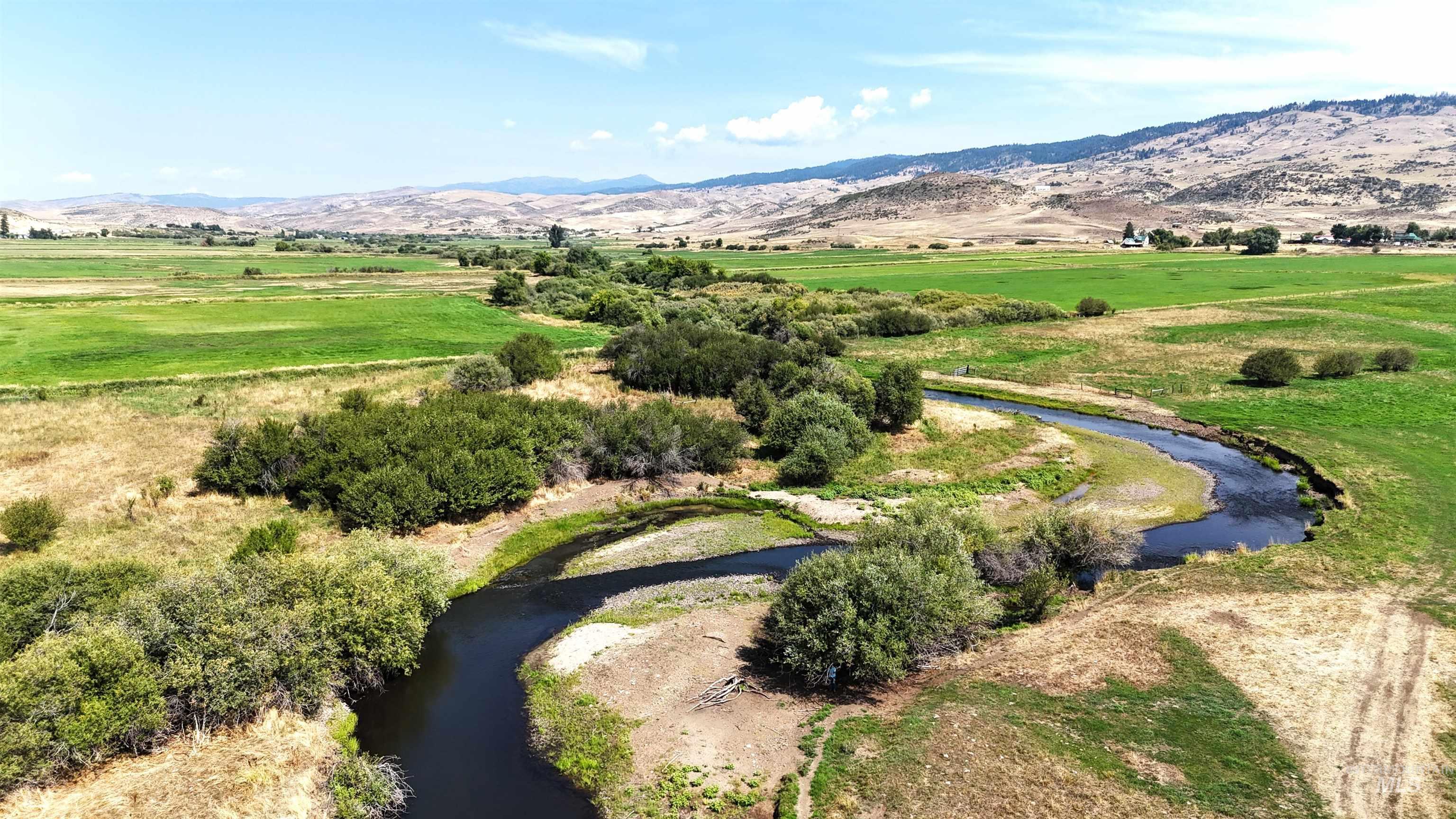 View of rural area with a water and mountain view and a pastoral area