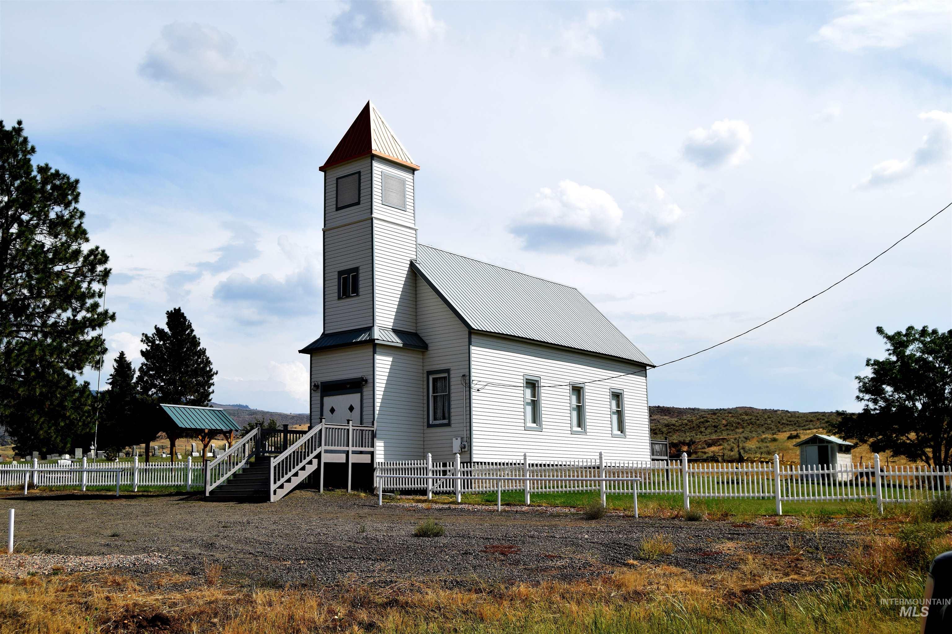 View of front of house with a metal roof and stairs