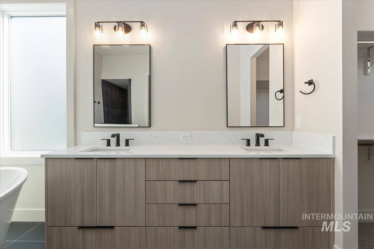 Full bath featuring double vanity and a freestanding bath