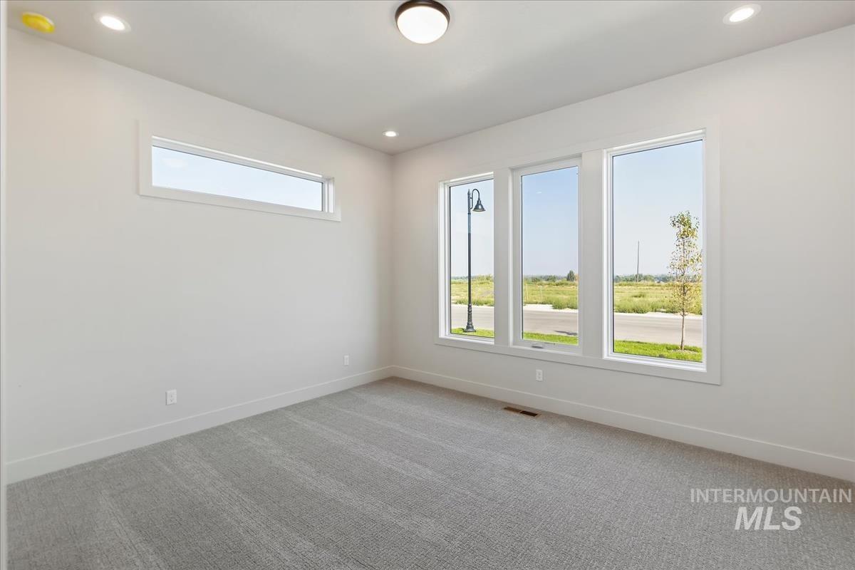 Carpeted spare room featuring recessed lighting and baseboards