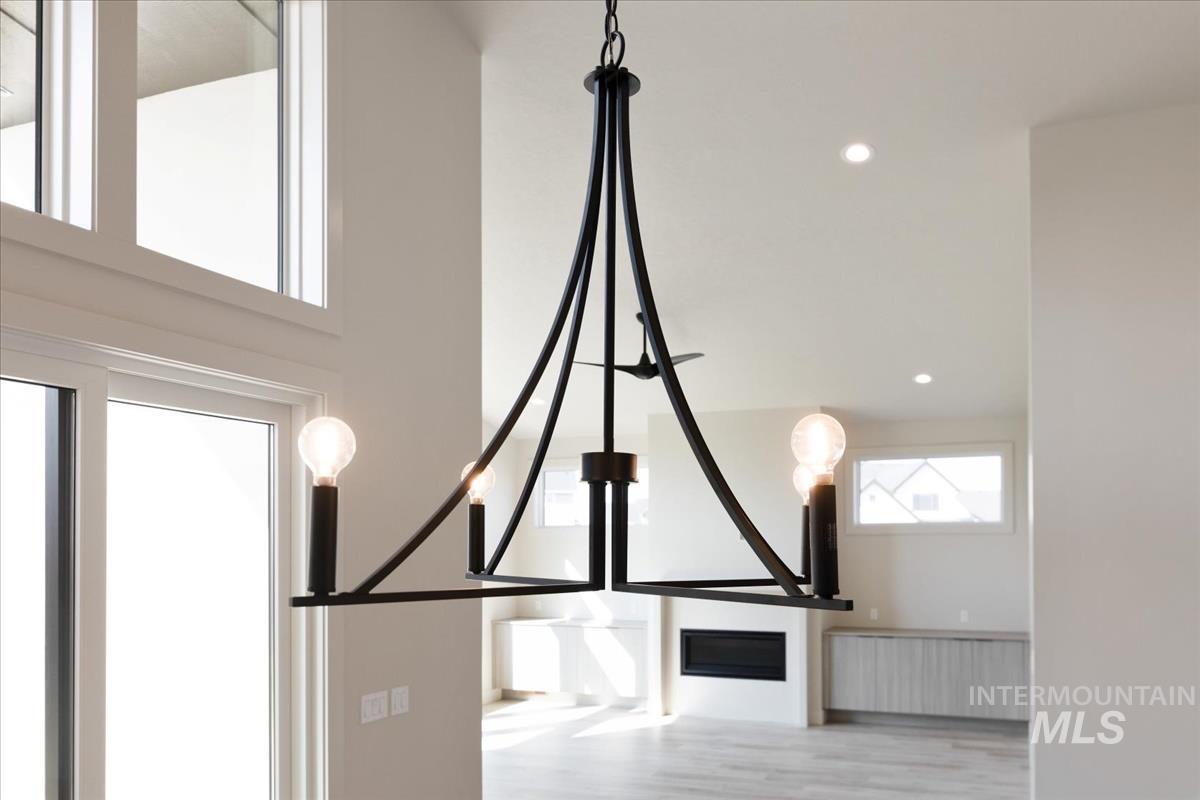 Detailed view of recessed lighting, wood finished floors, and a chandelier
