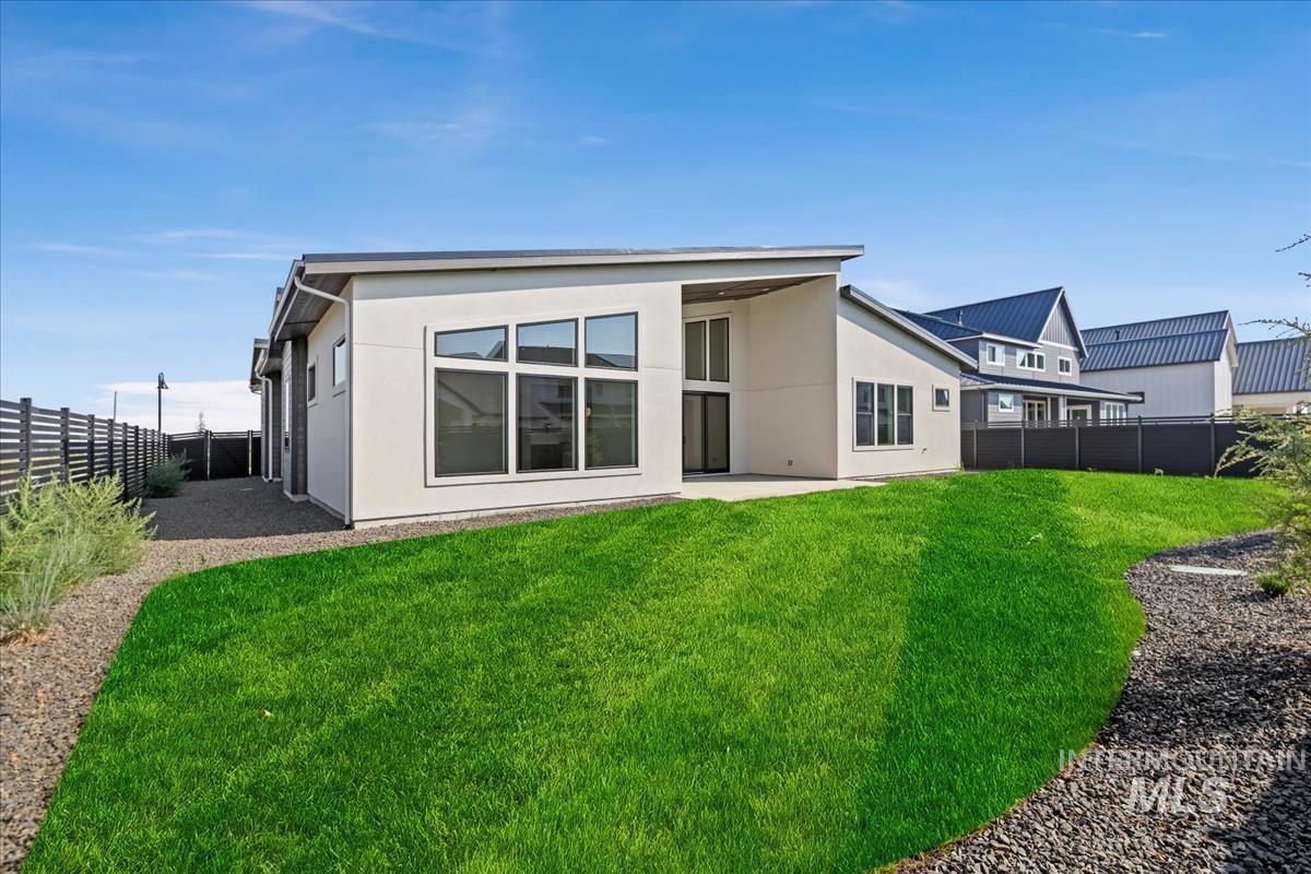 Back of house featuring a fenced backyard, a patio area, and stucco siding