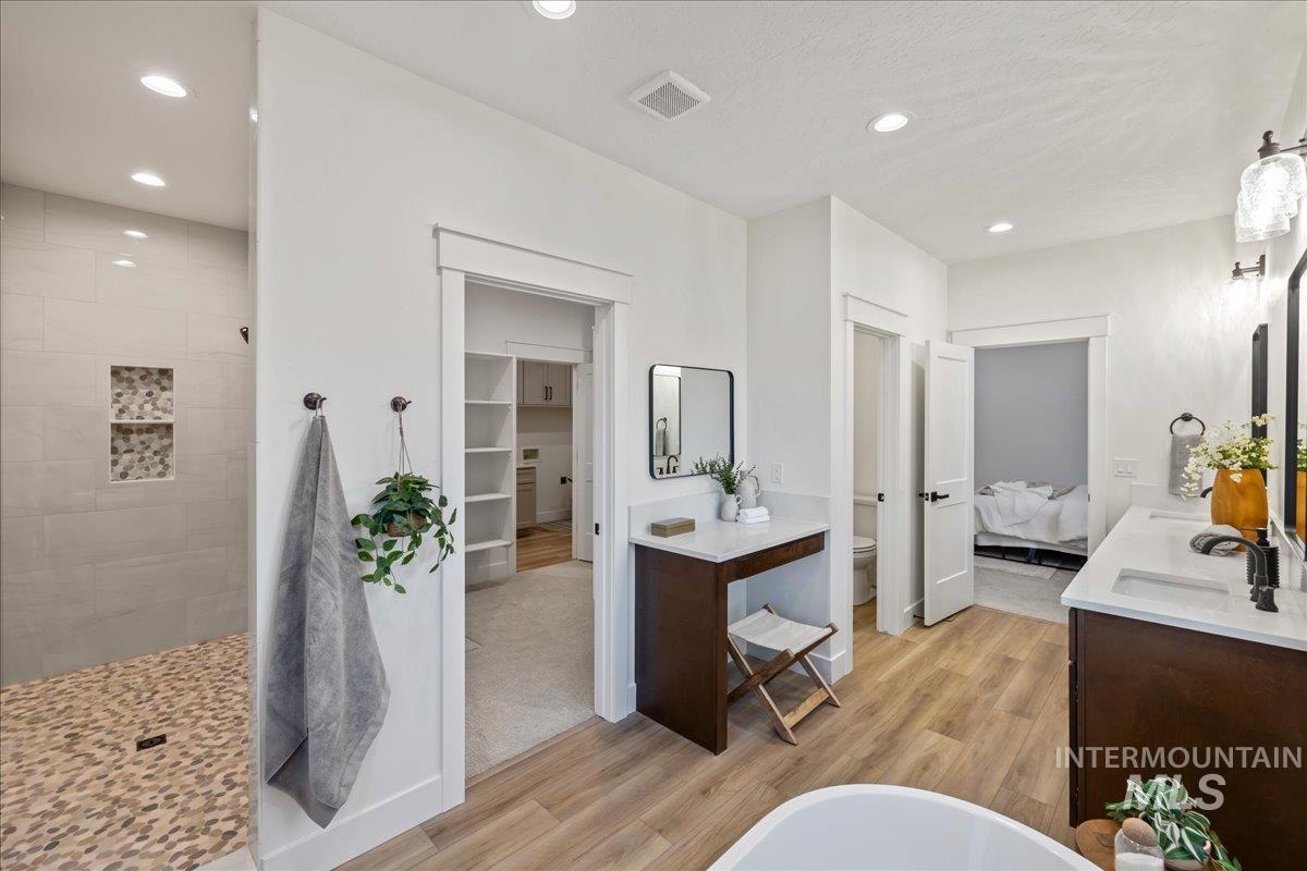 Bathroom with light wood-type flooring, double vanity, recessed lighting, ensuite bathroom, and a tile shower