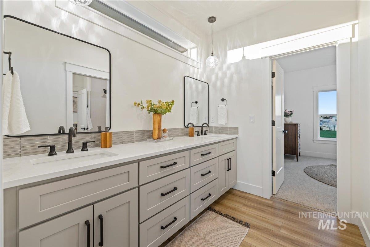 Full bathroom featuring double vanity and light wood-type flooring
