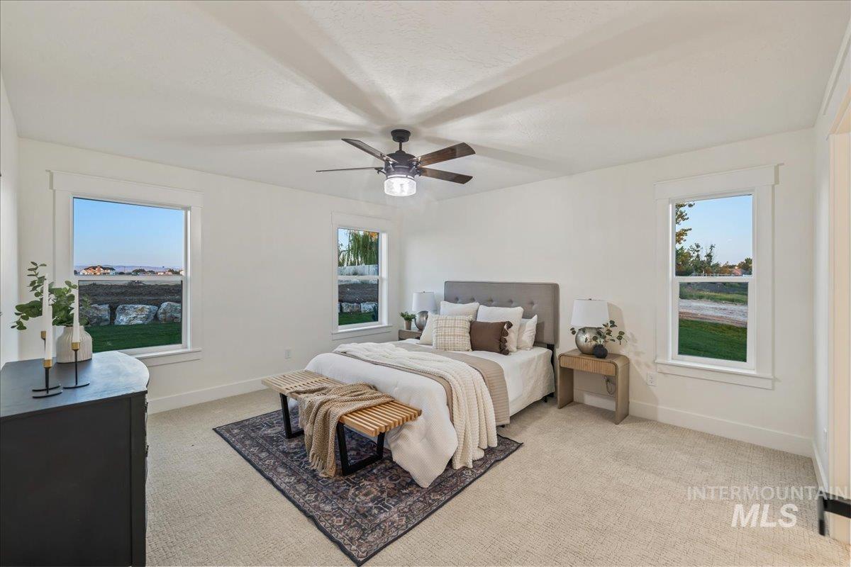 Bedroom with light carpet and a ceiling fan