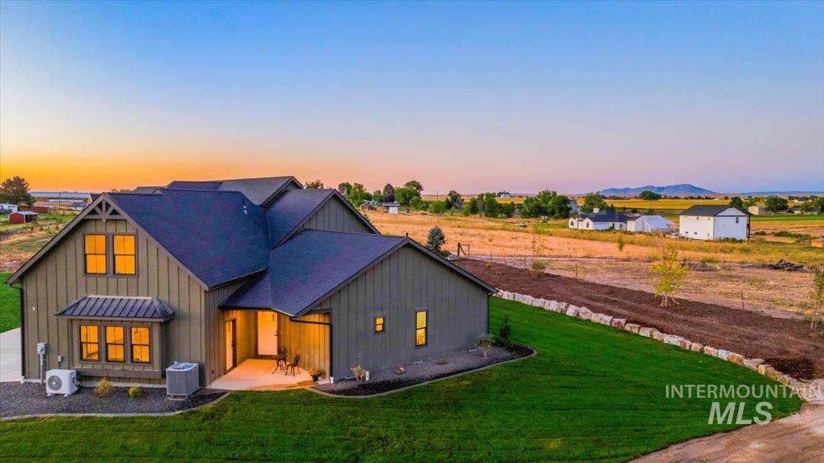 View of front of house featuring board and batten siding, a front lawn, a standing seam roof, and a metal roof