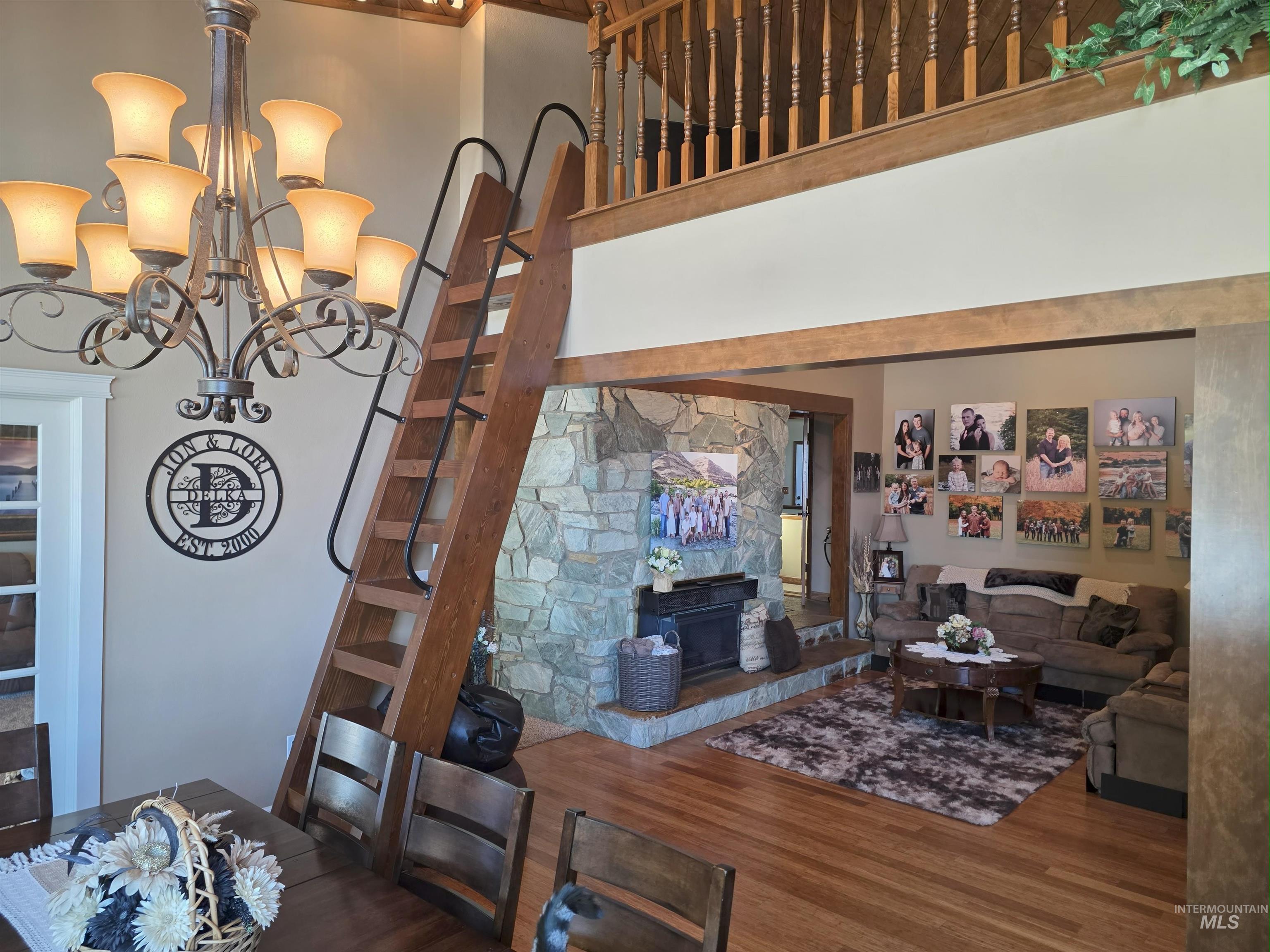 Living room featuring wood finished floors, a towering ceiling, and a chandelier