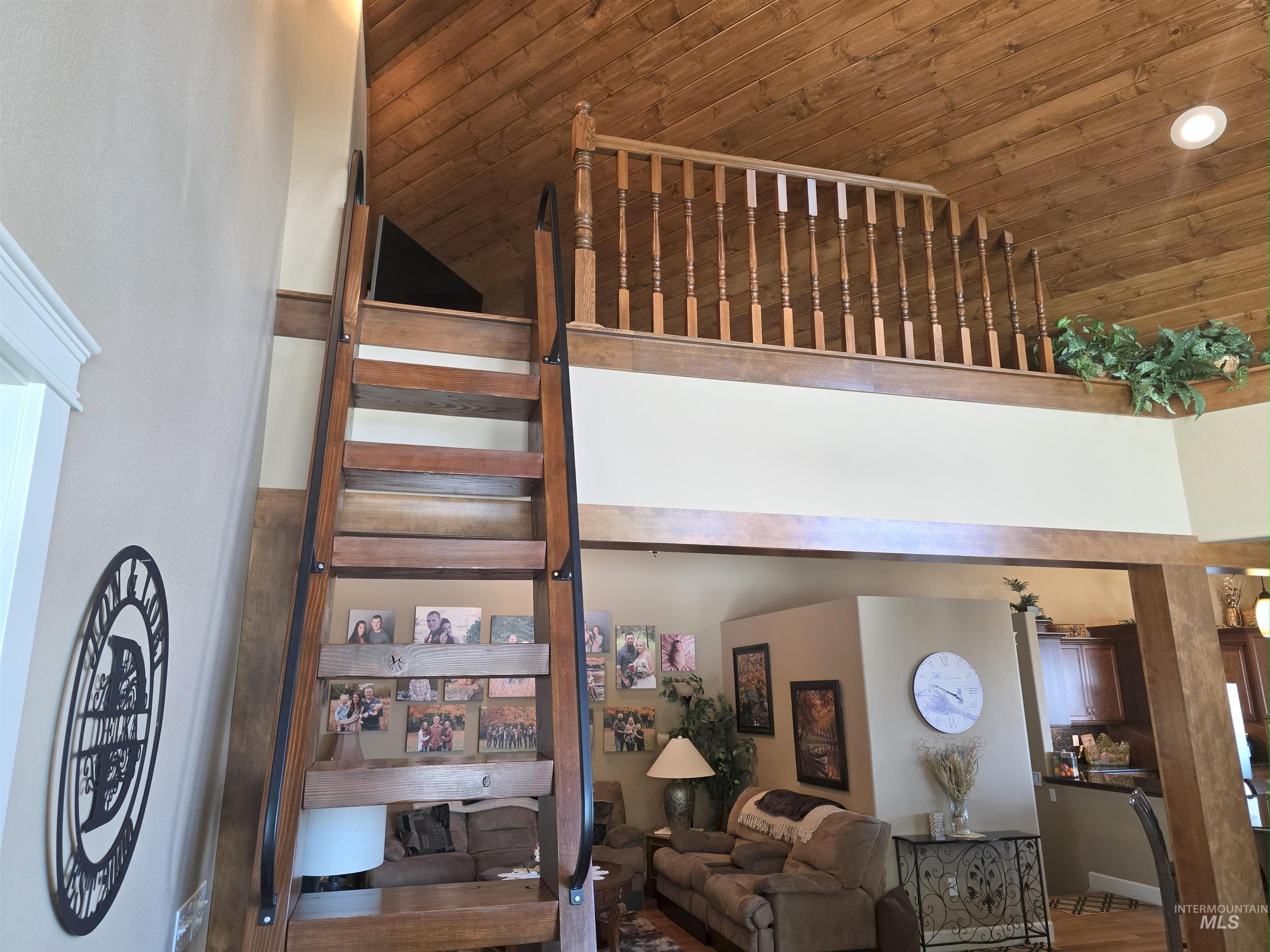 Stairway featuring wooden ceiling, high vaulted ceiling, and wood finished floors