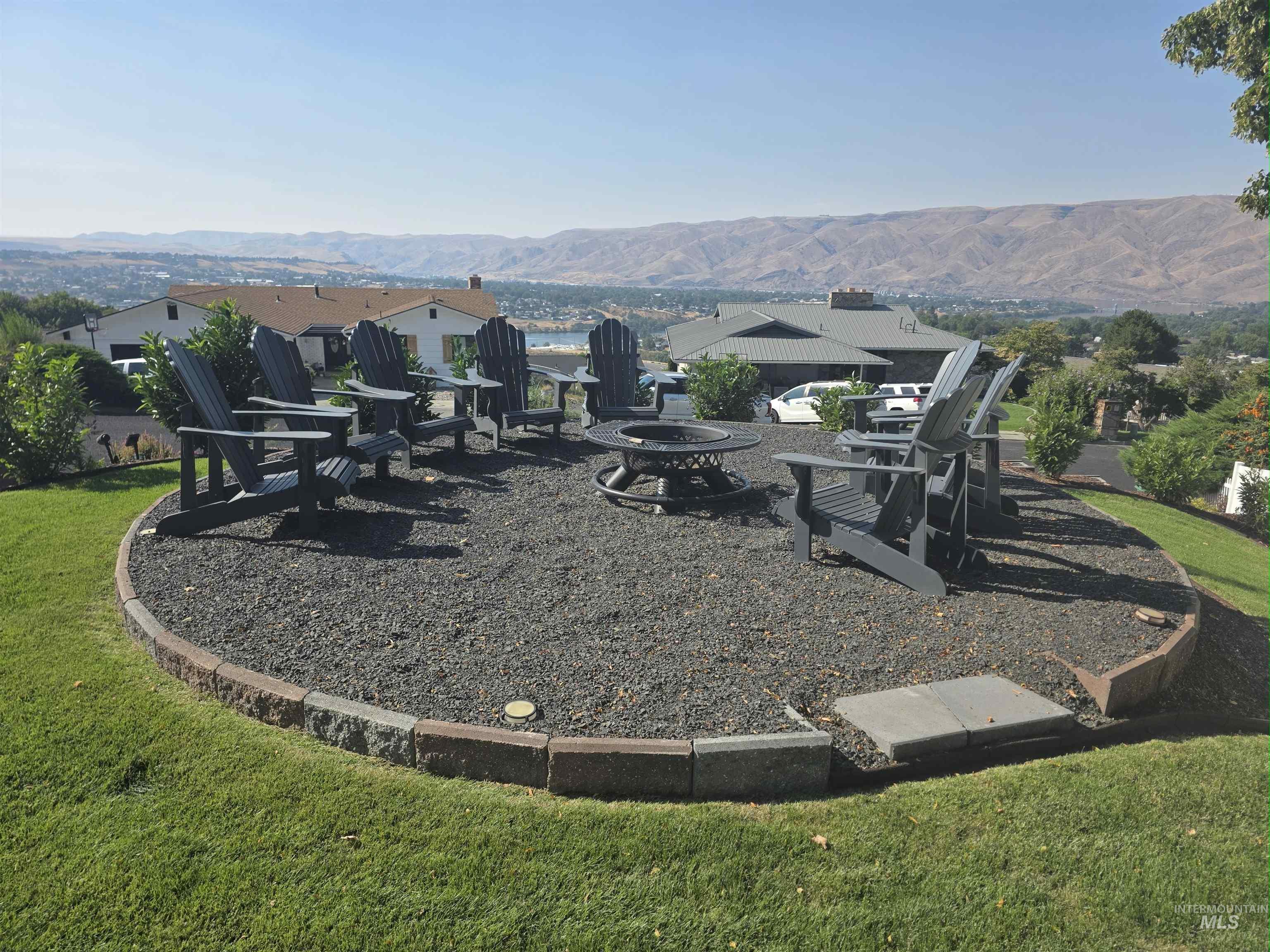 View of green lawn with a fire pit and a mountain view