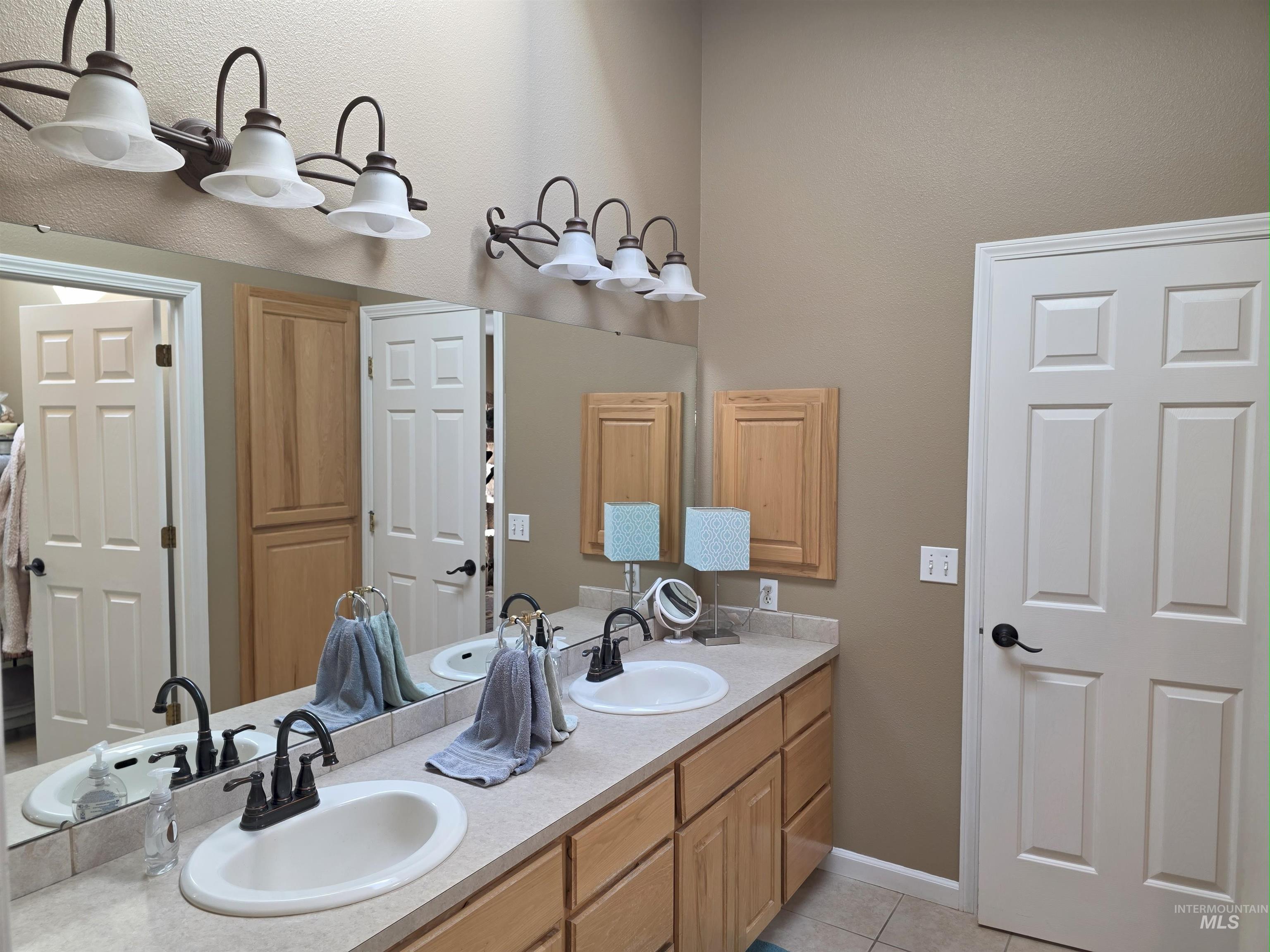 Bathroom featuring double vanity and light tile patterned flooring