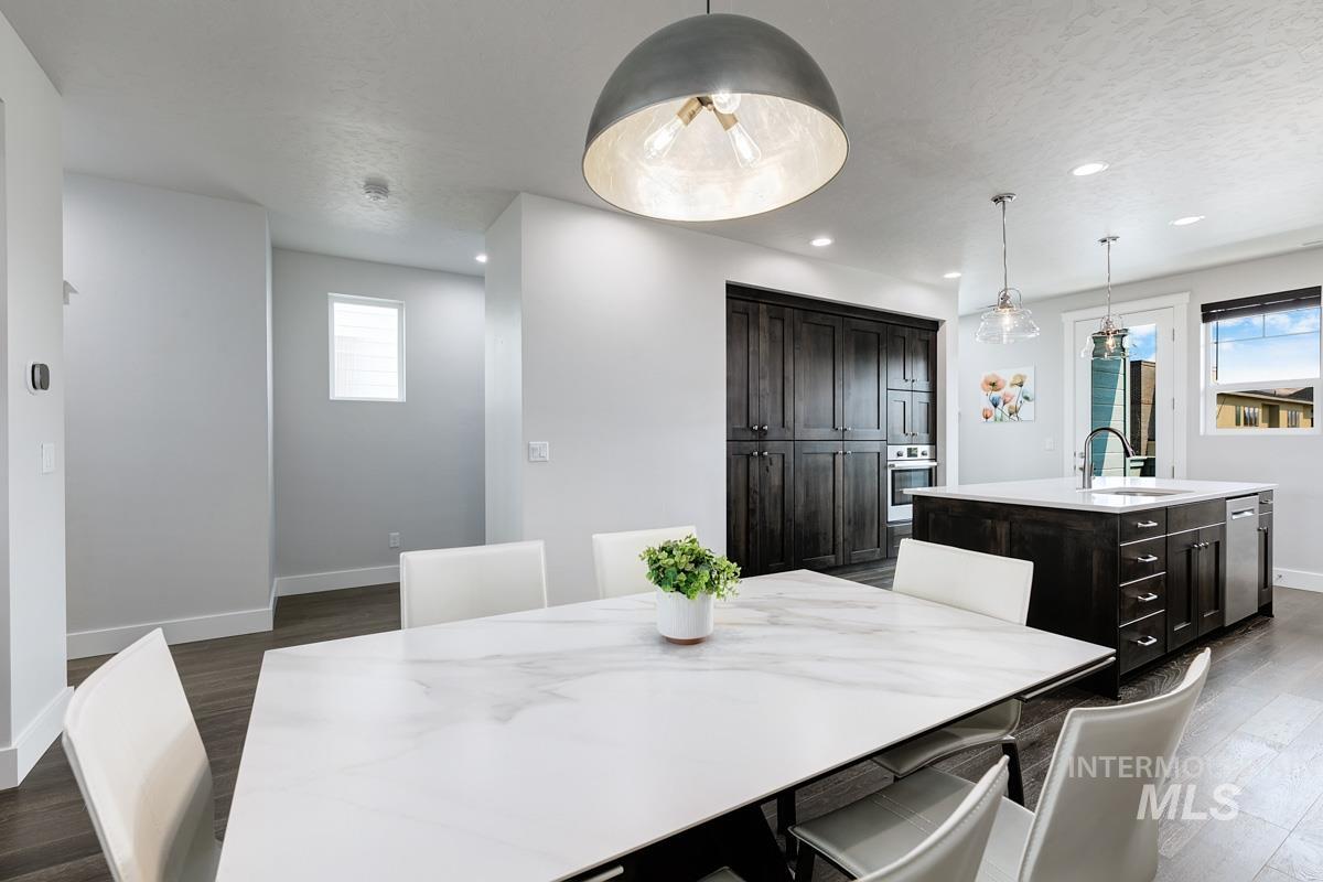 Dining area featuring dark wood-style flooring, plenty of natural light, recessed lighting, and a textured ceiling