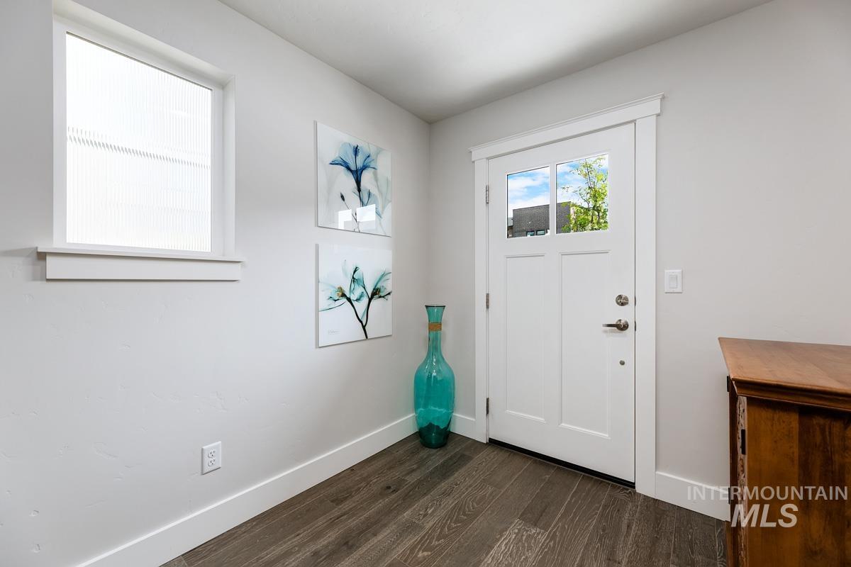Entryway with baseboards and dark wood-style floors