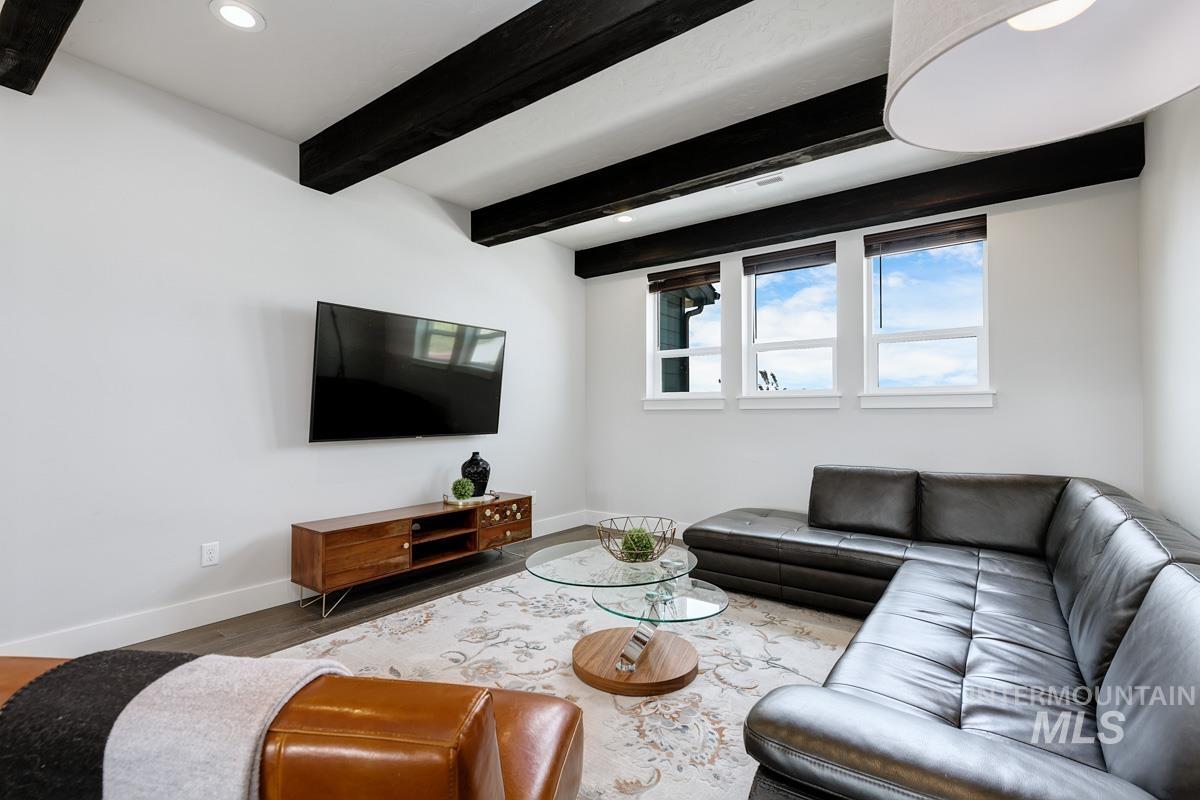 Living room with beam ceiling, wood finished floors, and recessed lighting