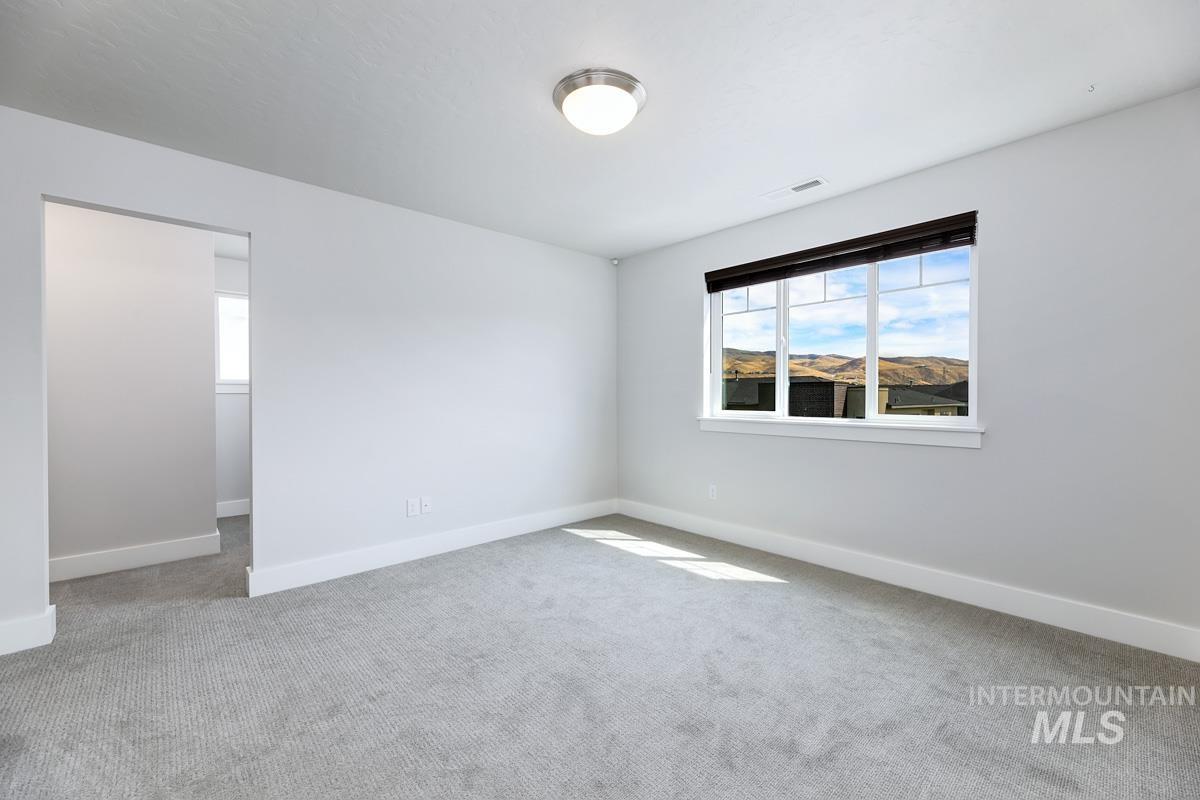 Large second Primary bedroom with light colored carpet and baseboards