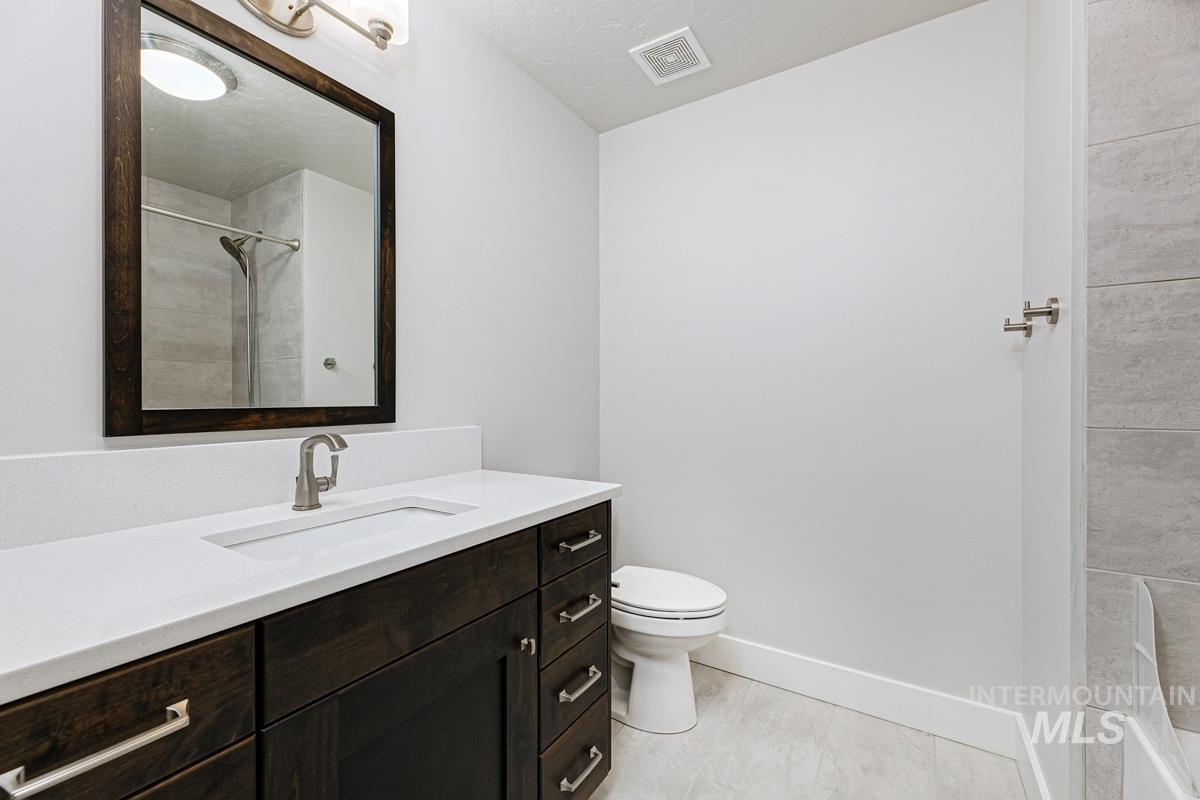 Full bathroom featuring vanity, a textured ceiling, and a shower