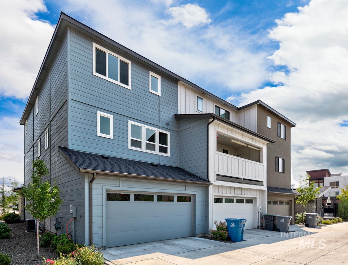View of front of house featuring a balcony, board and batten siding, an attached garage, and concrete driveway