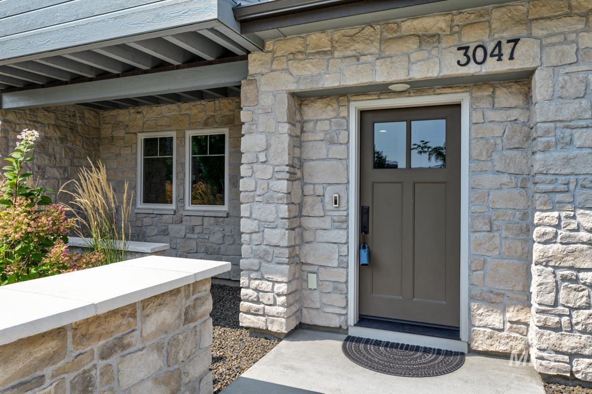 Doorway to property featuring stone siding