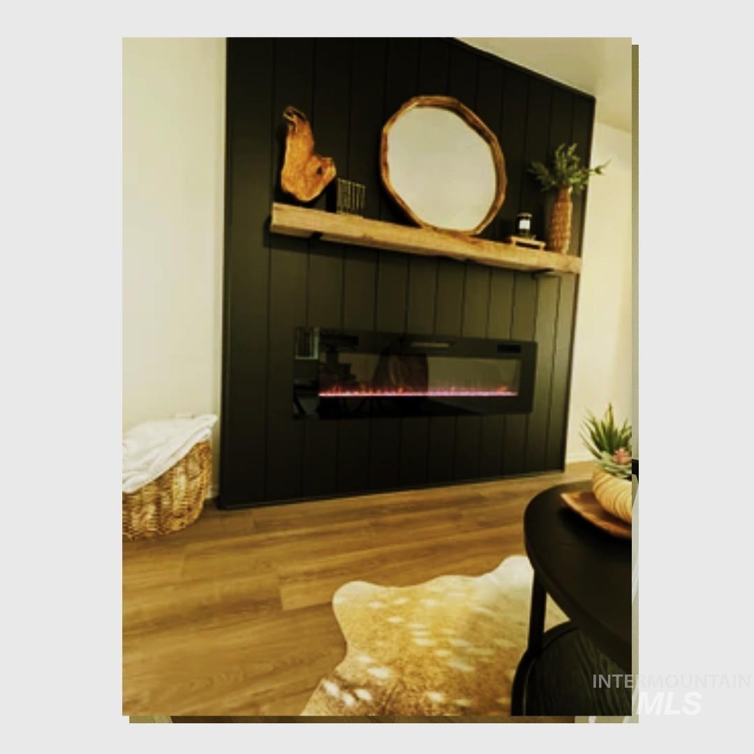 Detailed view of wood finished floors and a glass covered fireplace