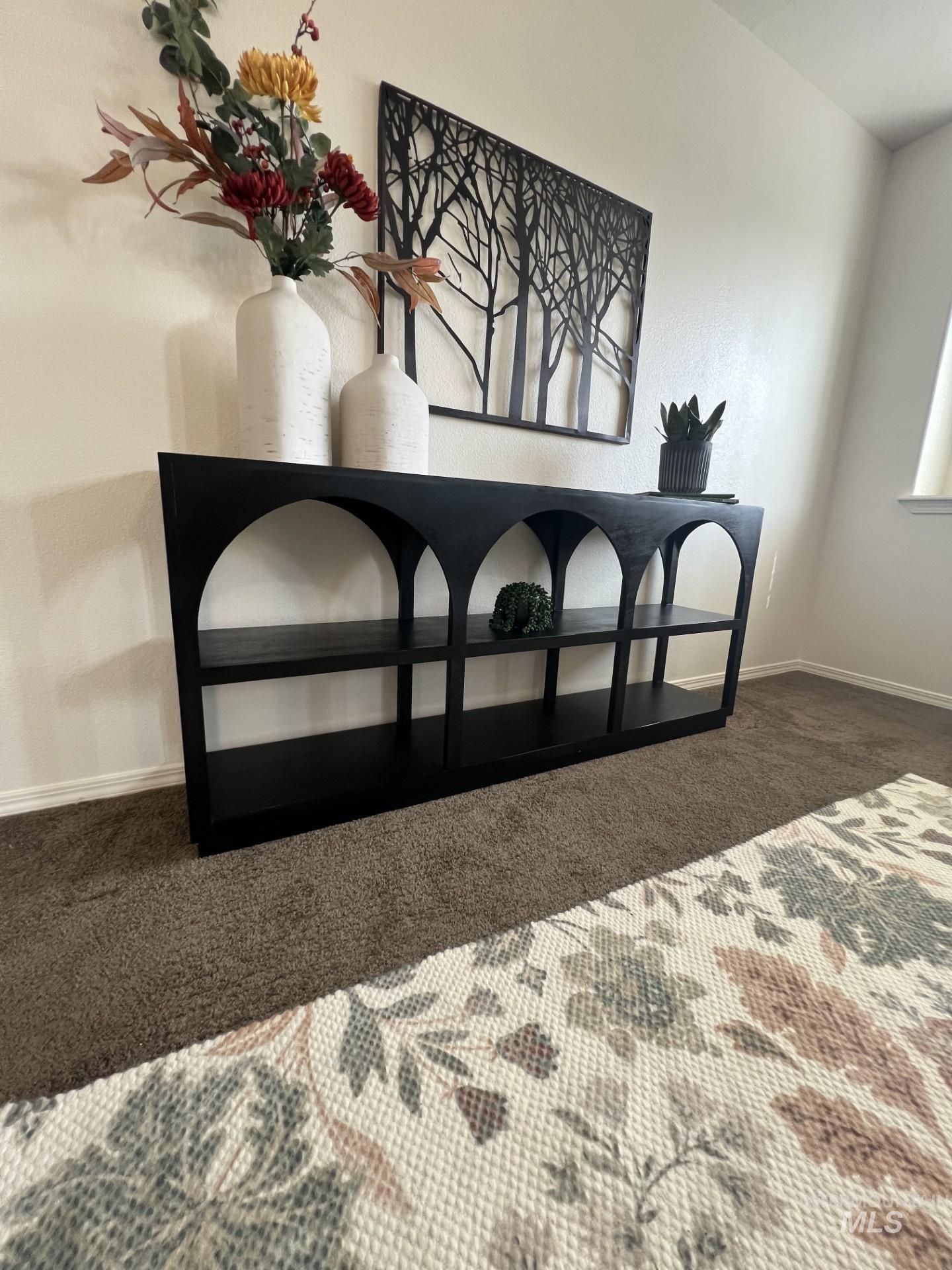 Bedroom featuring dark carpet and baseboards