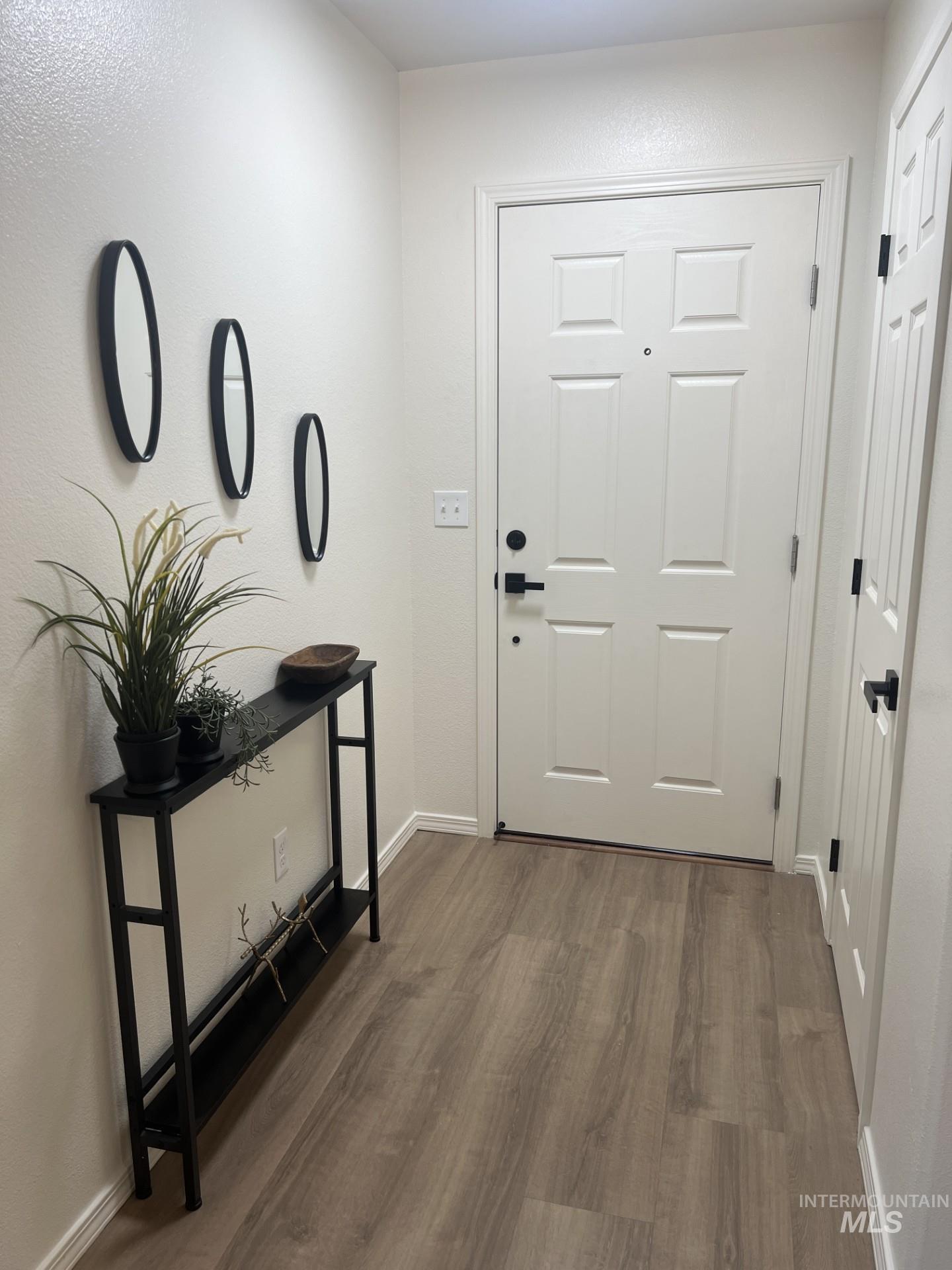 Entryway with wood finished floors and baseboards