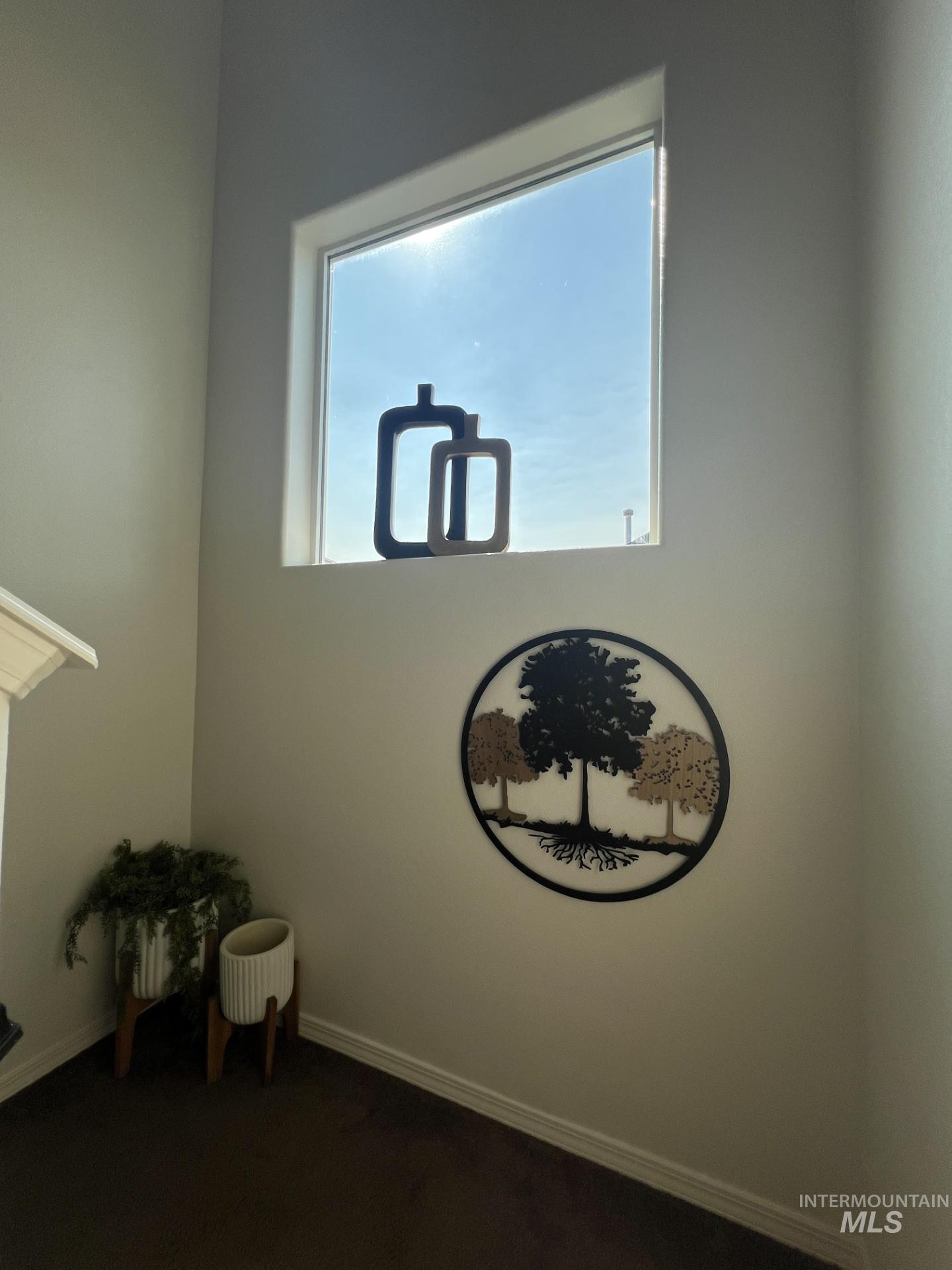 Unfurnished room with baseboards and dark carpet