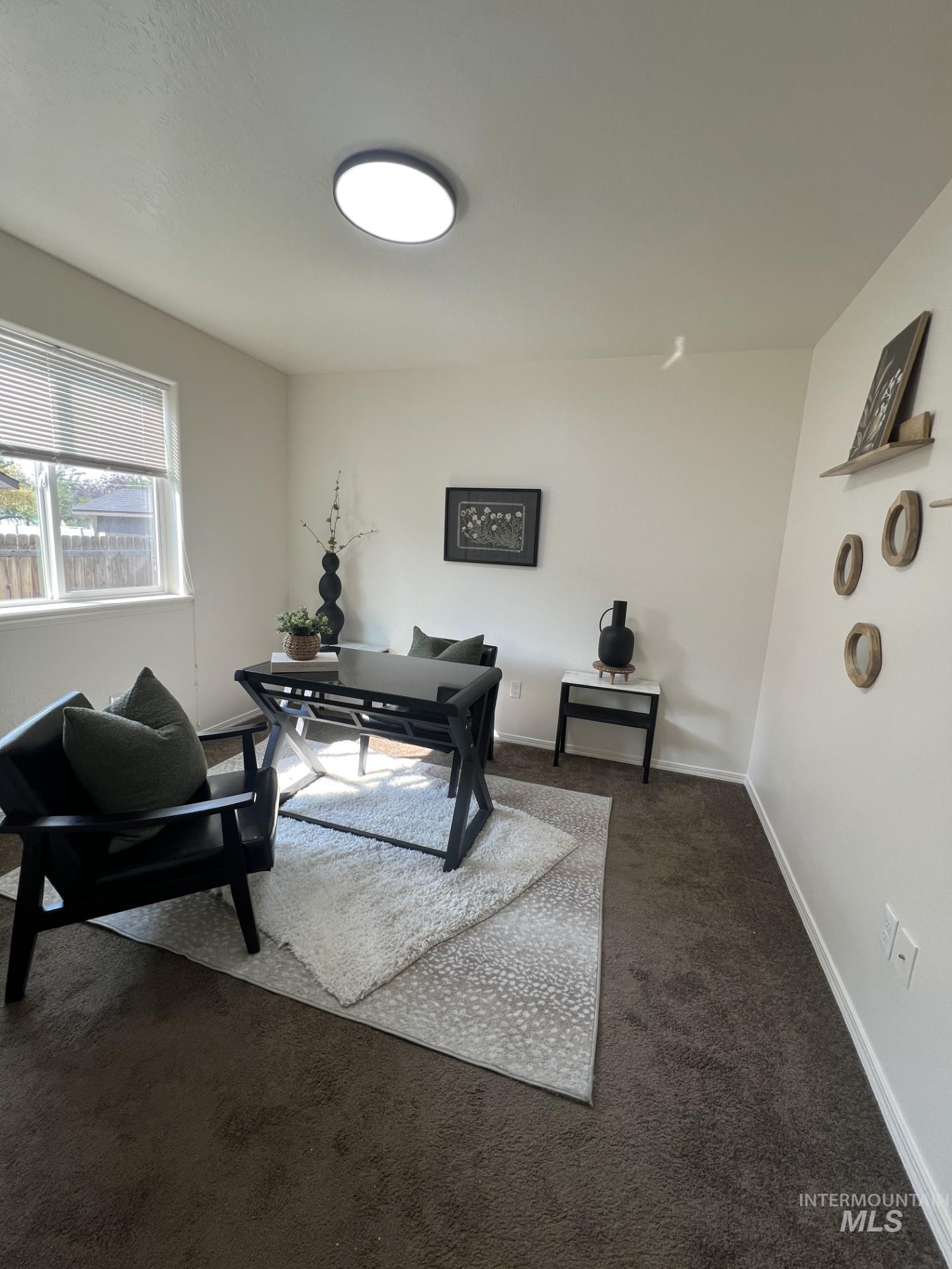 Office area featuring dark colored carpet and baseboards