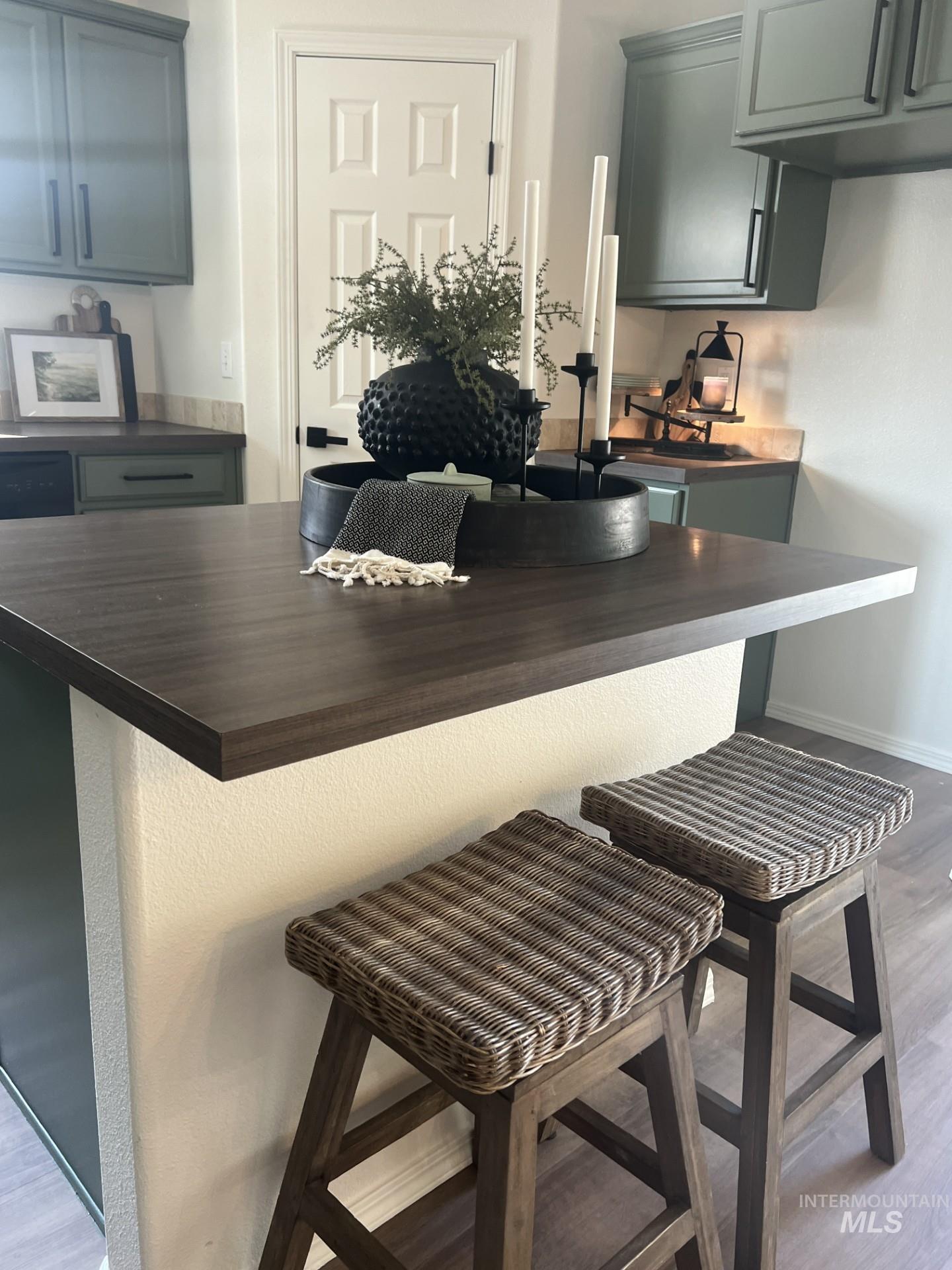 Kitchen with dark wood-style floors, a kitchen breakfast bar, gray cabinetry, and butcher block countertops