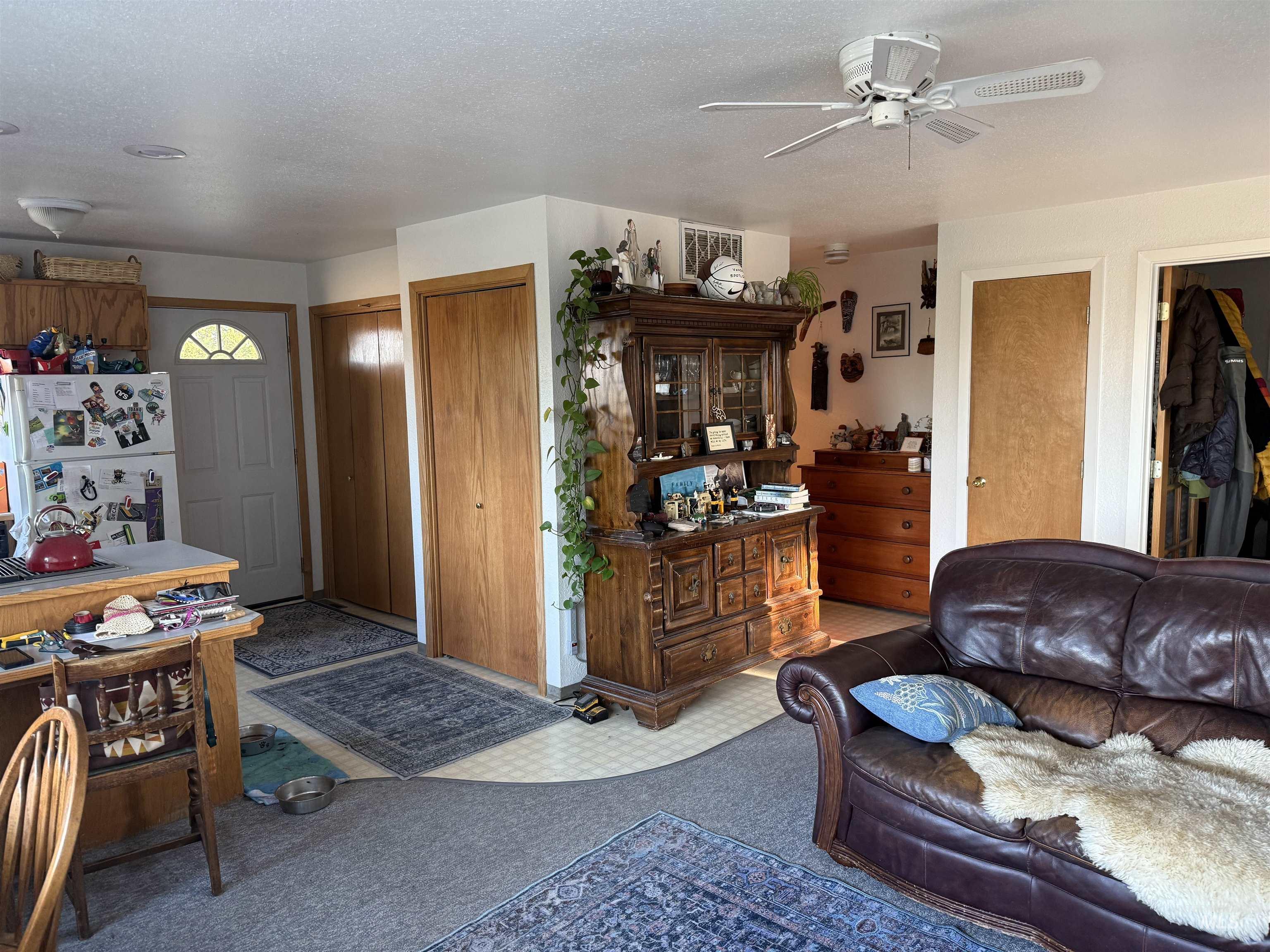 Carpeted living room with a textured ceiling and a ceiling fan
