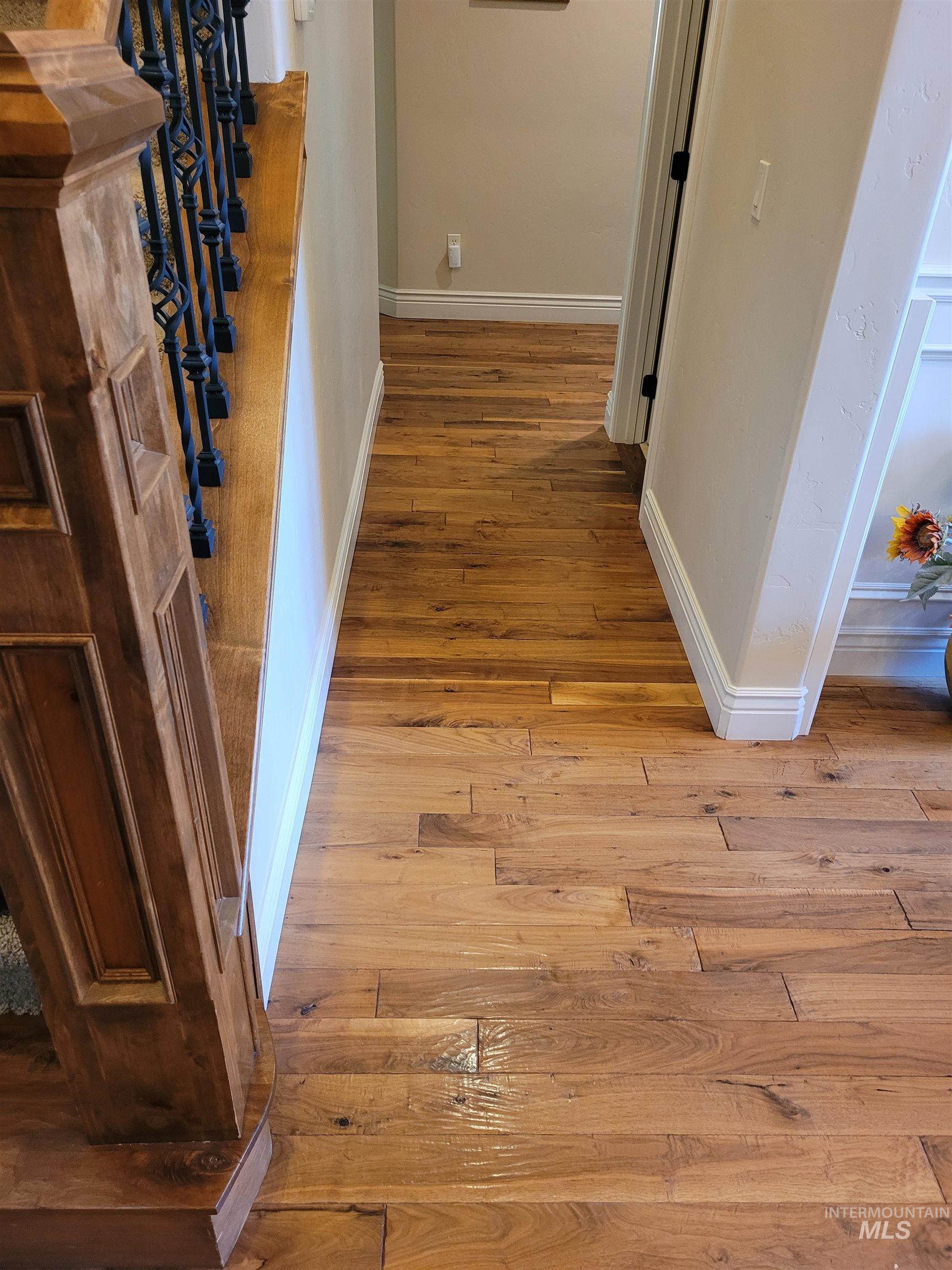 Hallway with light wood-style floors and baseboards