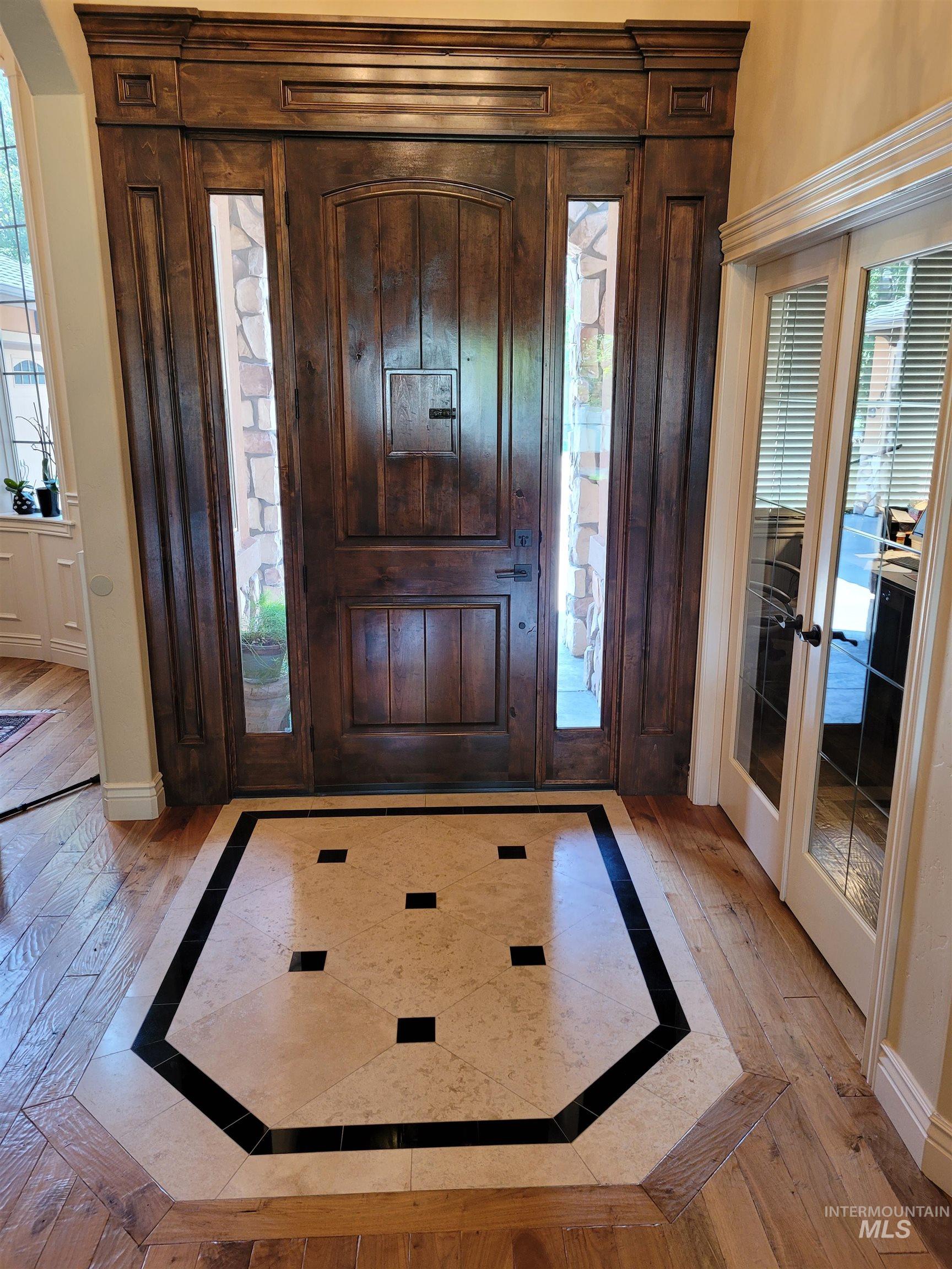 Foyer featuring inlaid floor details and french doors