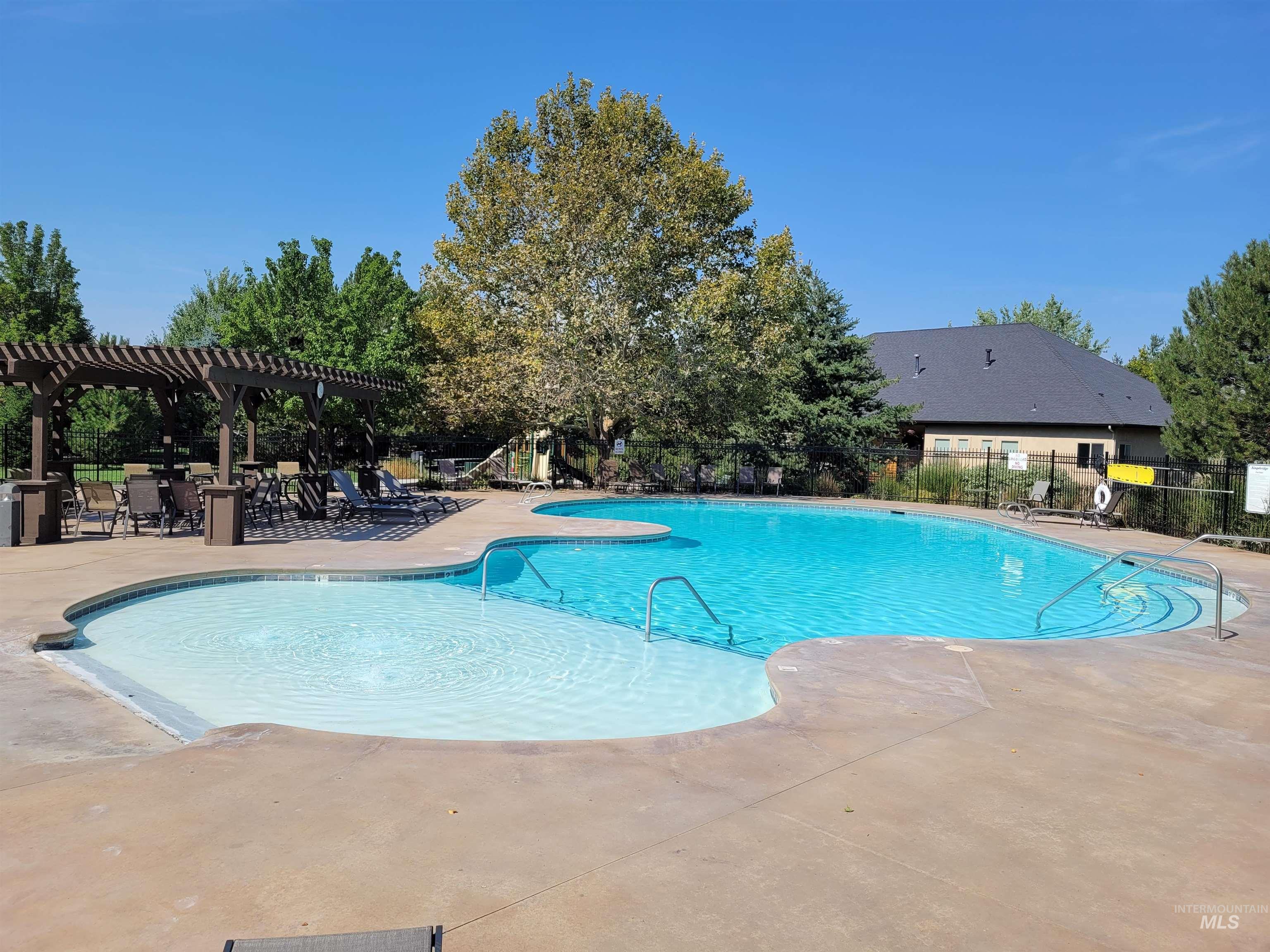 Community pool with a patio and a pergola