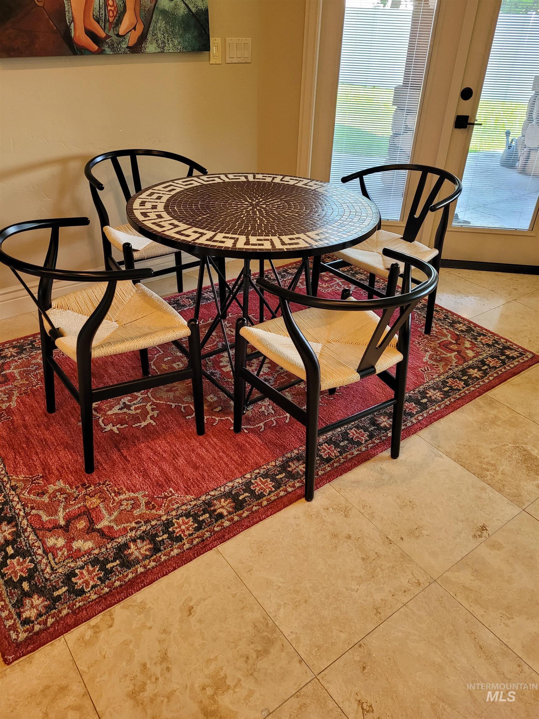 Dining space with light tile patterned flooring and healthy amount of natural light