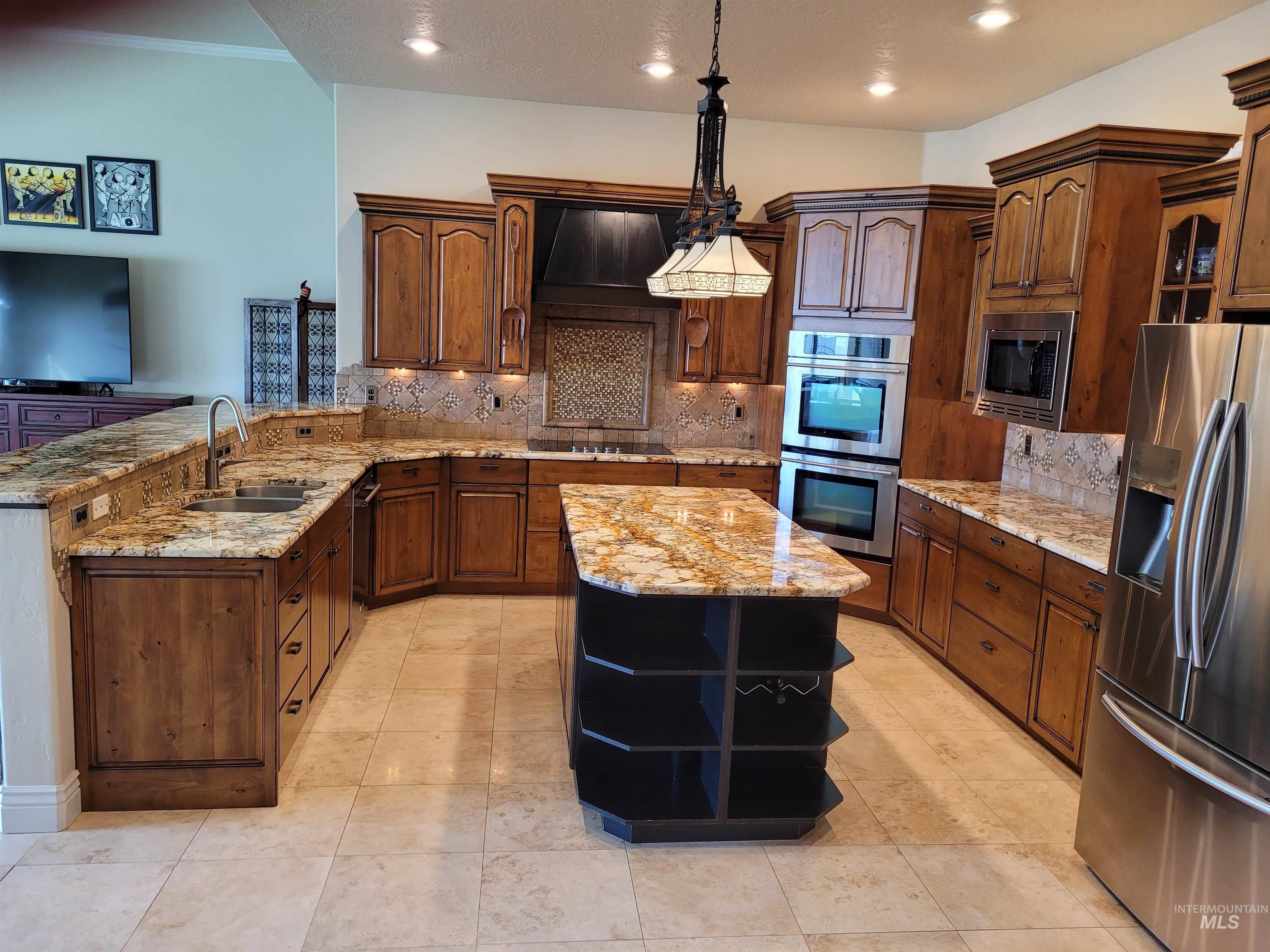 Kitchen featuring open shelves, stainless steel appliances, a peninsula, light stone counters, and recessed lighting