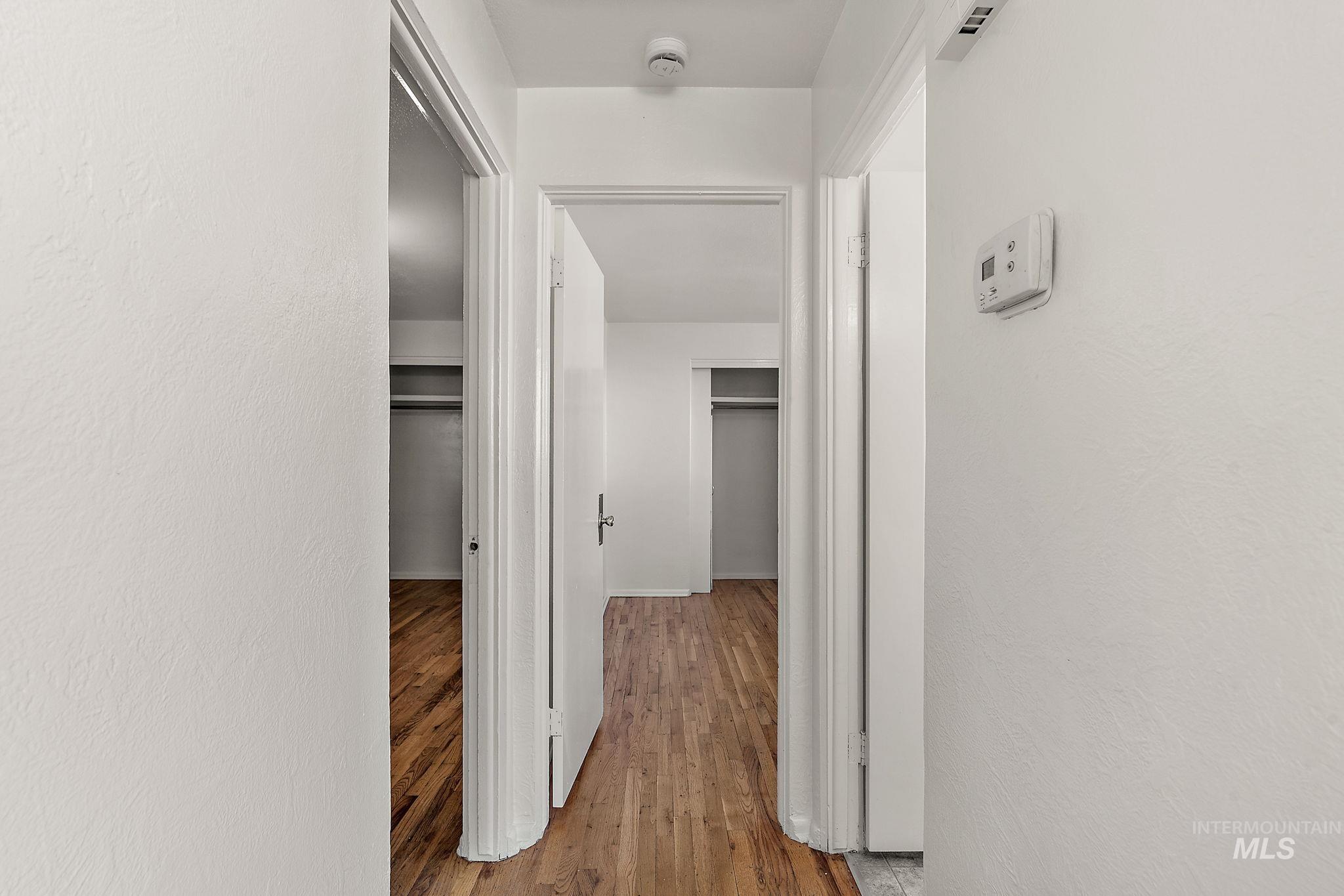 Hall featuring light wood-style floors and a textured wall