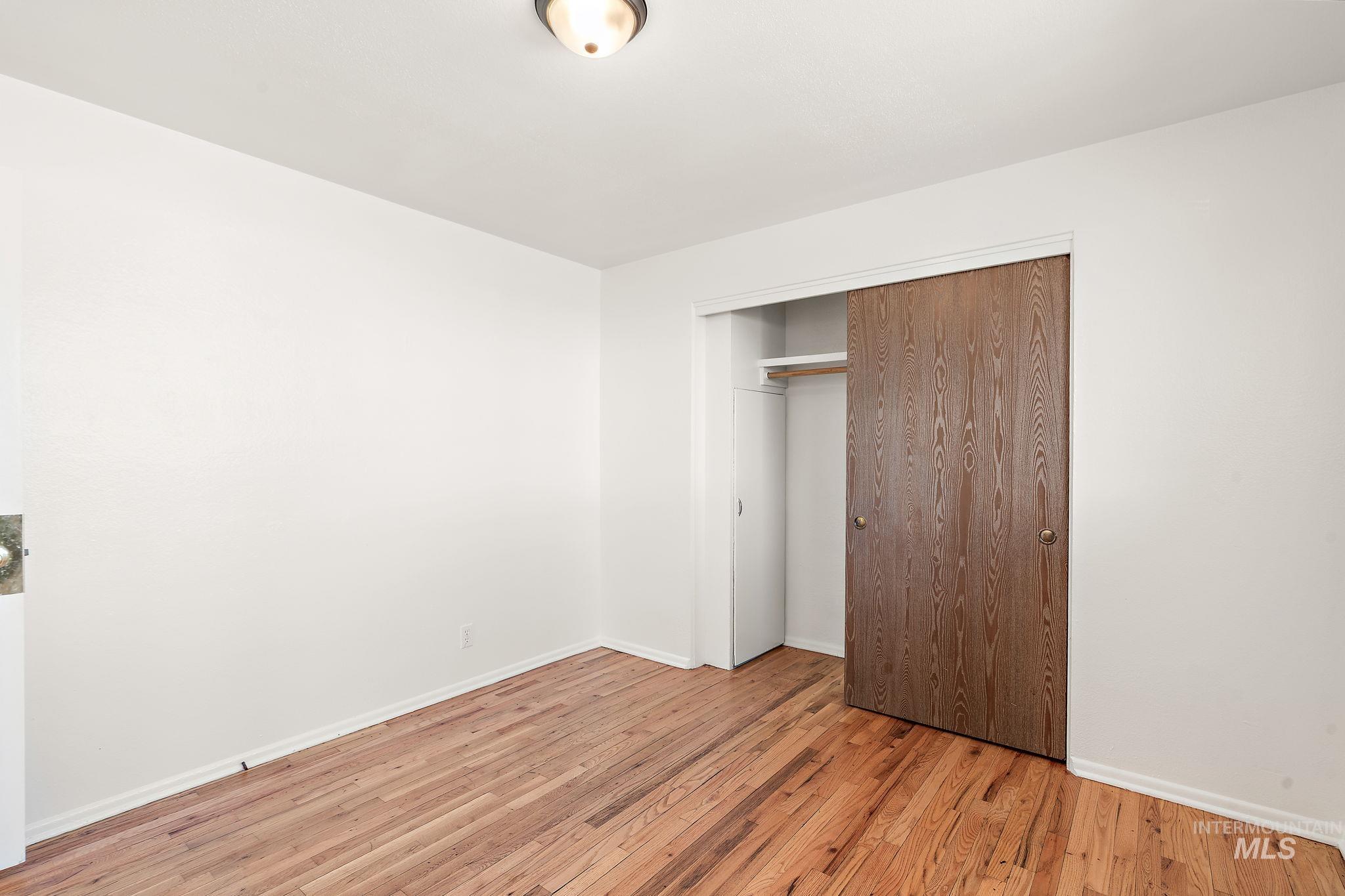 Unfurnished bedroom featuring light wood-type flooring and a closet