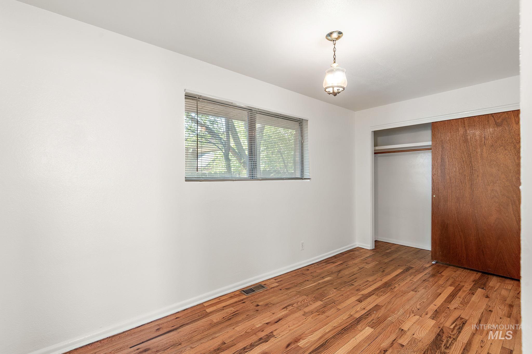 Unfurnished bedroom with wood finished floors and a closet
