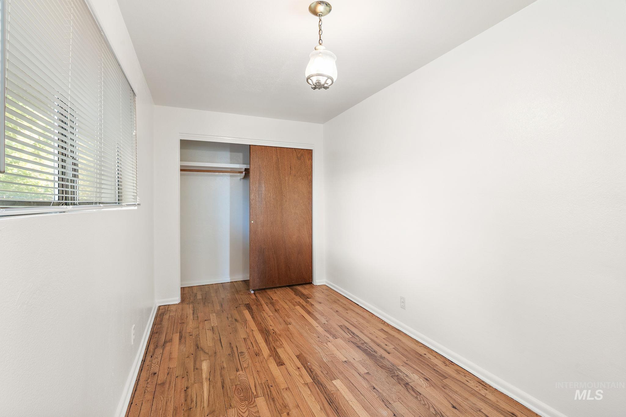 Unfurnished bedroom with hardwood / wood-style floors and a closet