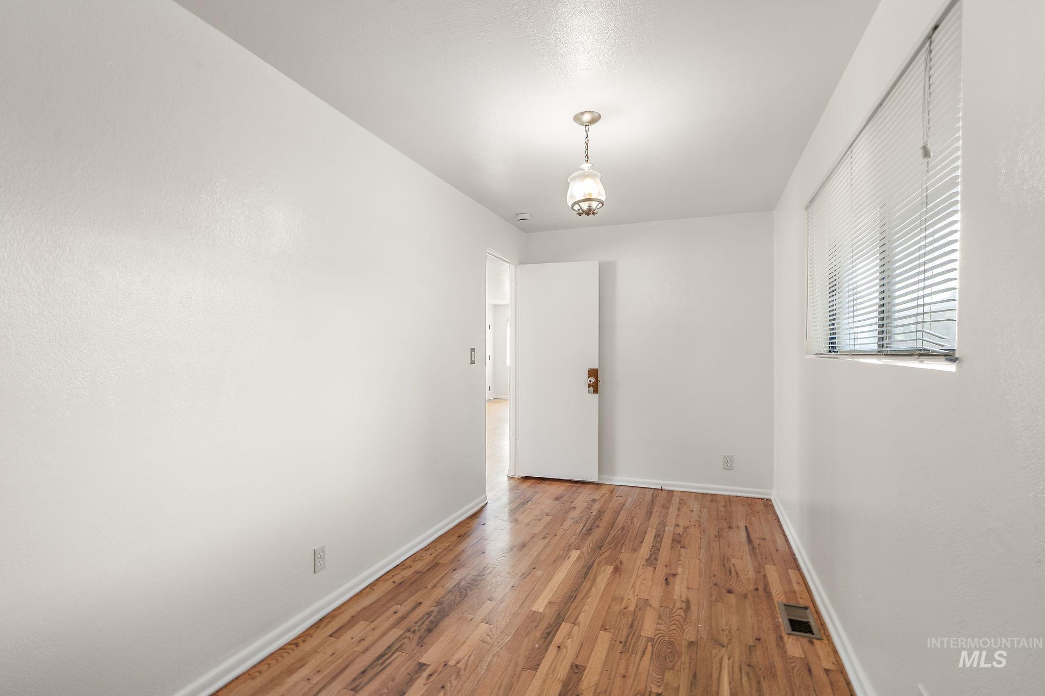 Unfurnished dining area with light wood-style floors and baseboards