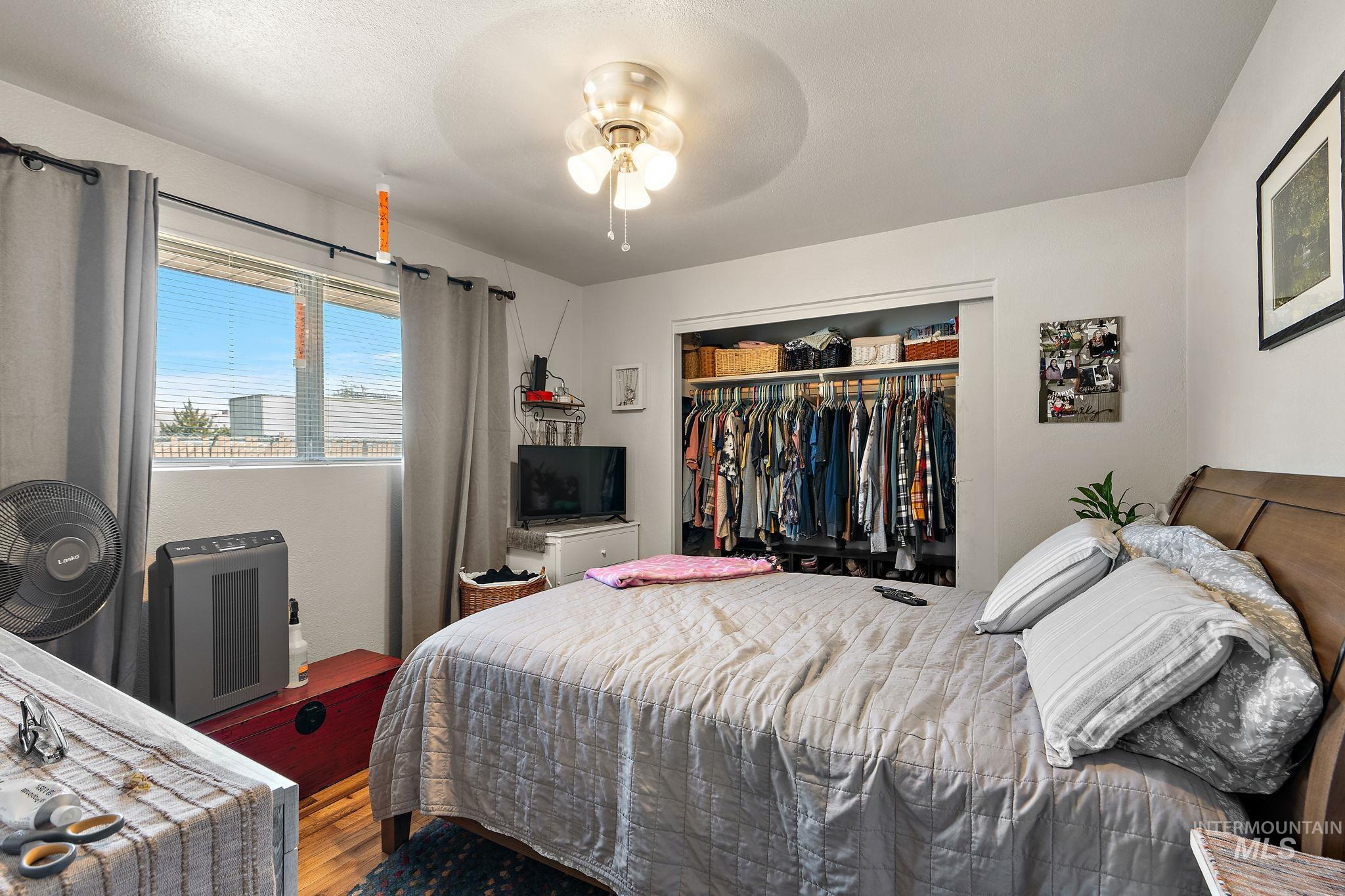 Bedroom featuring wood finished floors, a closet, and ceiling fan