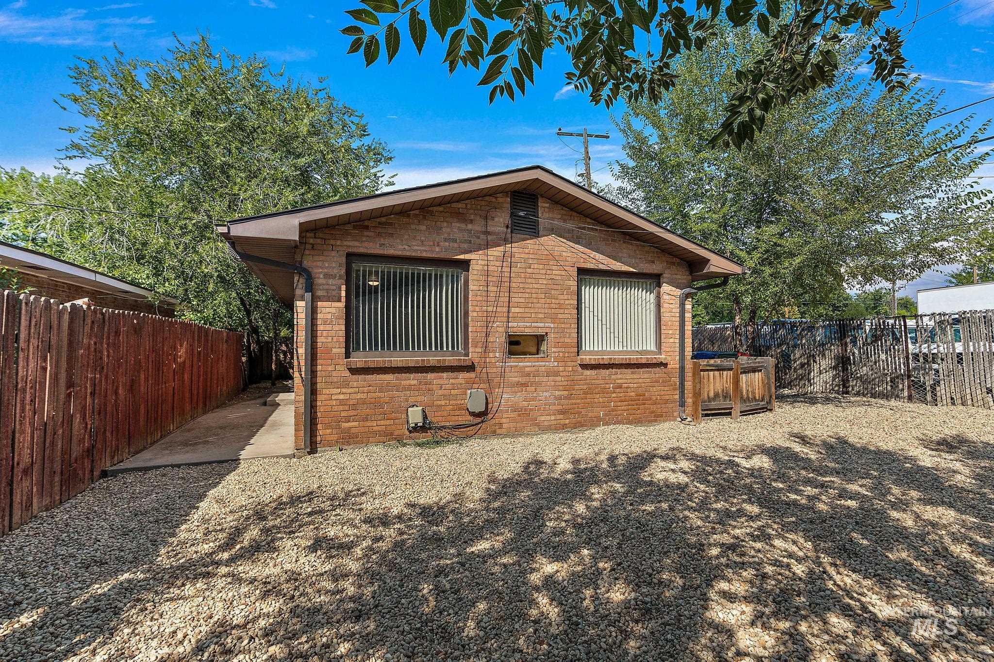 Back of property featuring a fenced backyard and brick siding