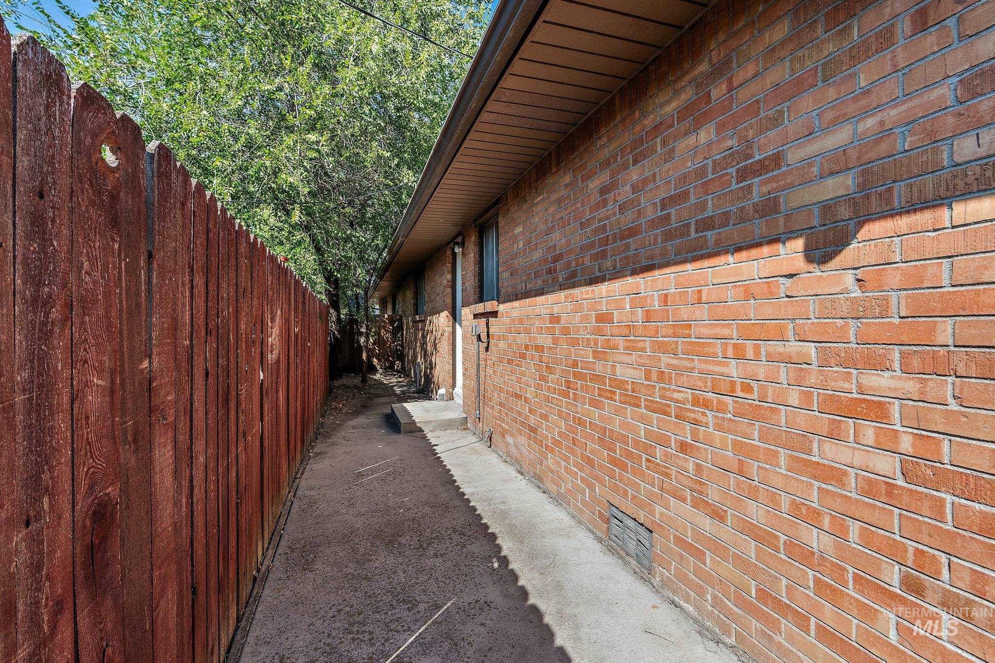 View of side of home with brick siding and crawl space