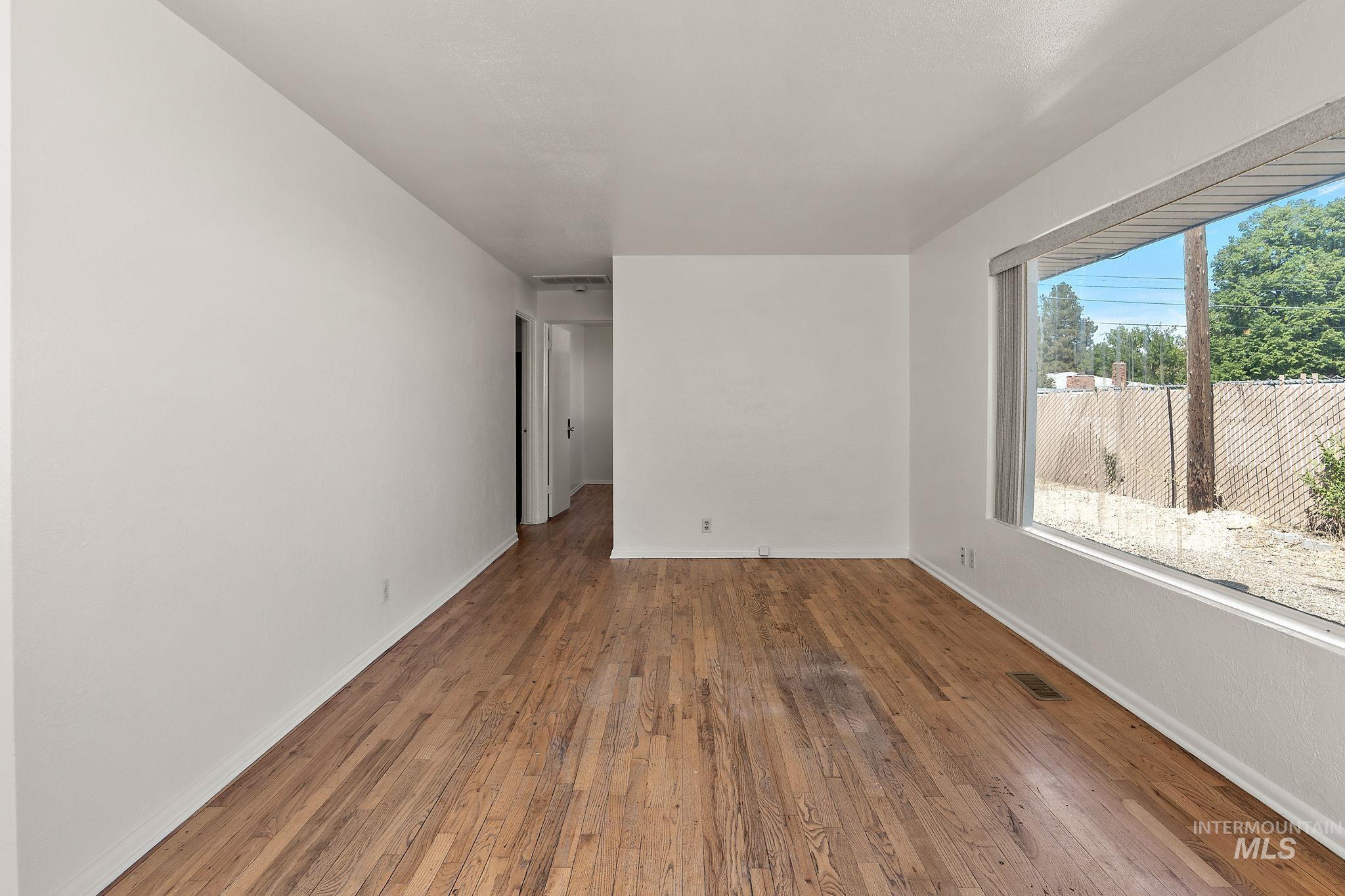 Spare room featuring wood finished floors and baseboards