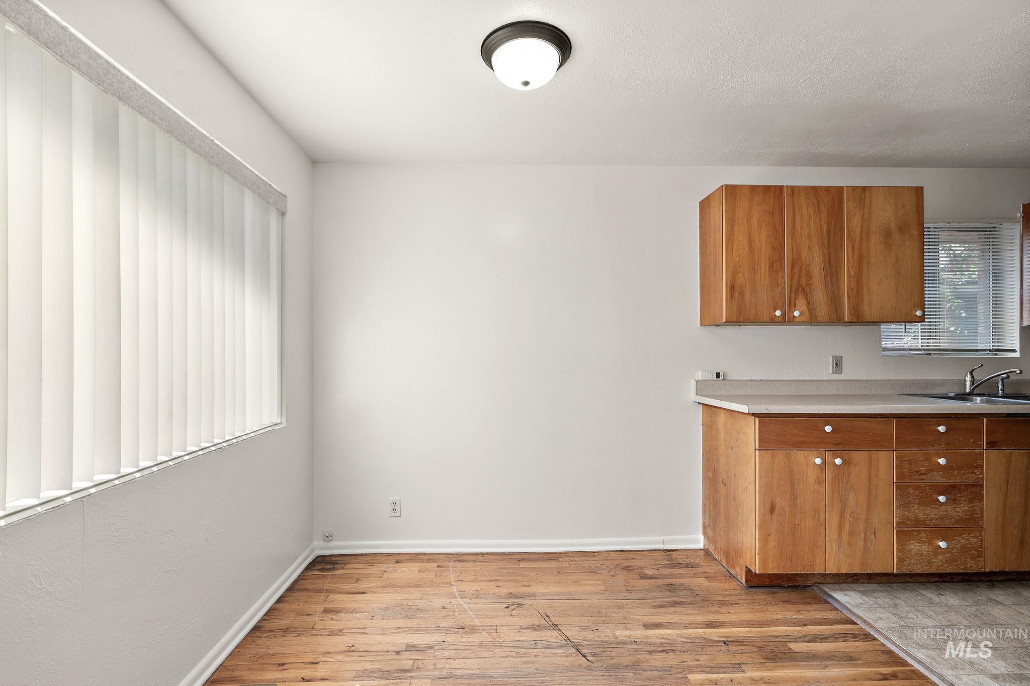 Kitchen featuring light wood-style flooring, brown cabinets, and light countertops