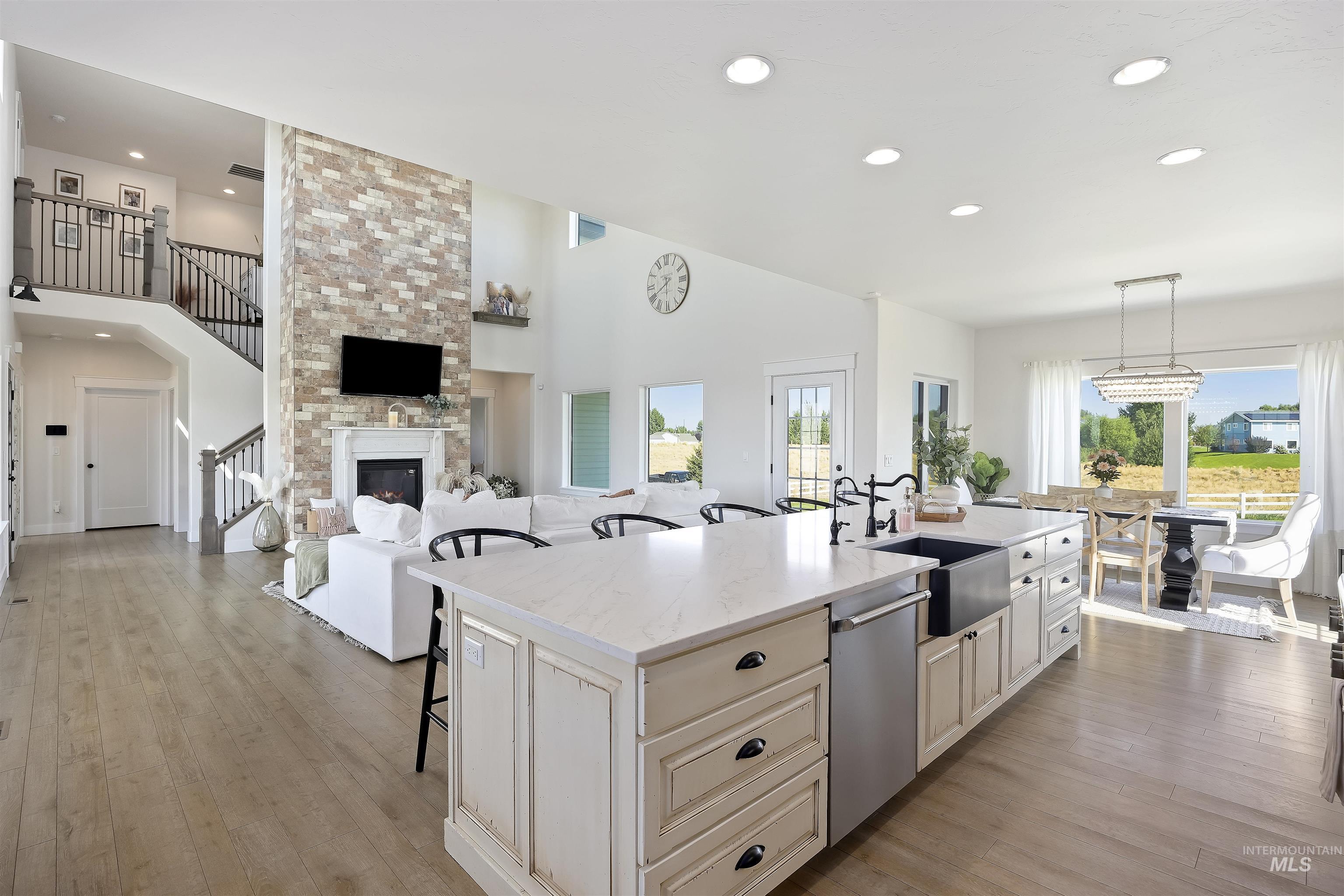 Kitchen featuring a kitchen bar, open floor plan, light stone counters, dishwasher, and recessed lighting