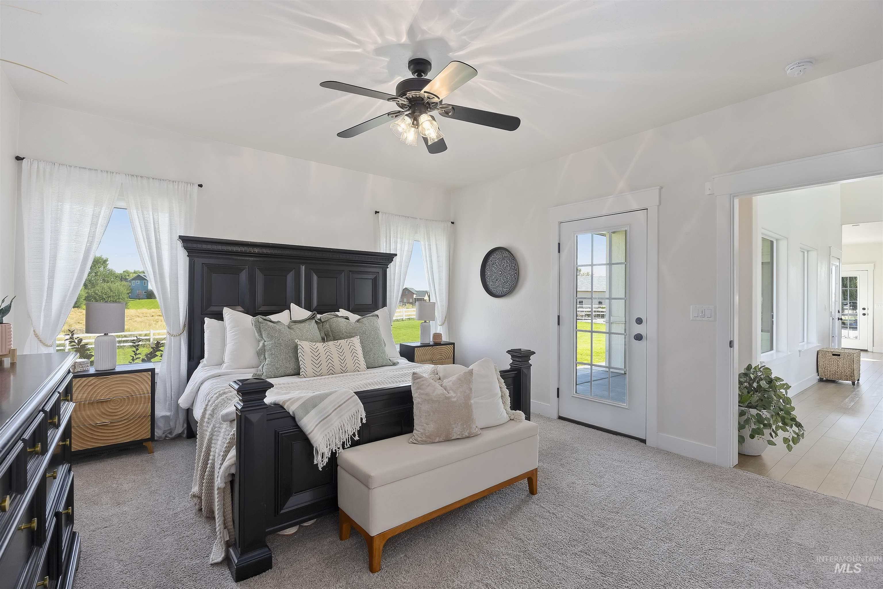 Bedroom featuring dark carpet, multiple windows, access to outside, and ceiling fan